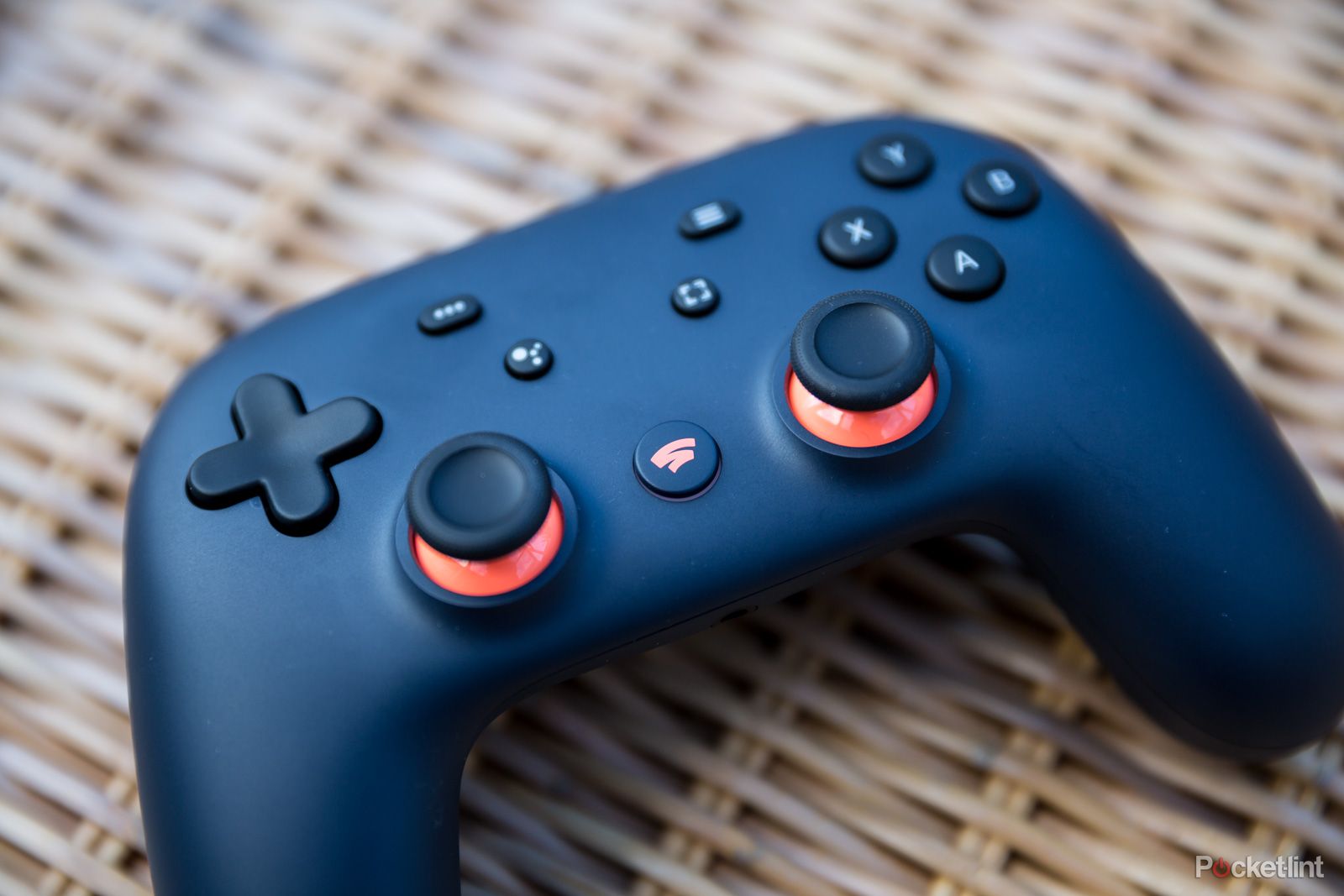 Google stadia controller laid on a wicker surface
