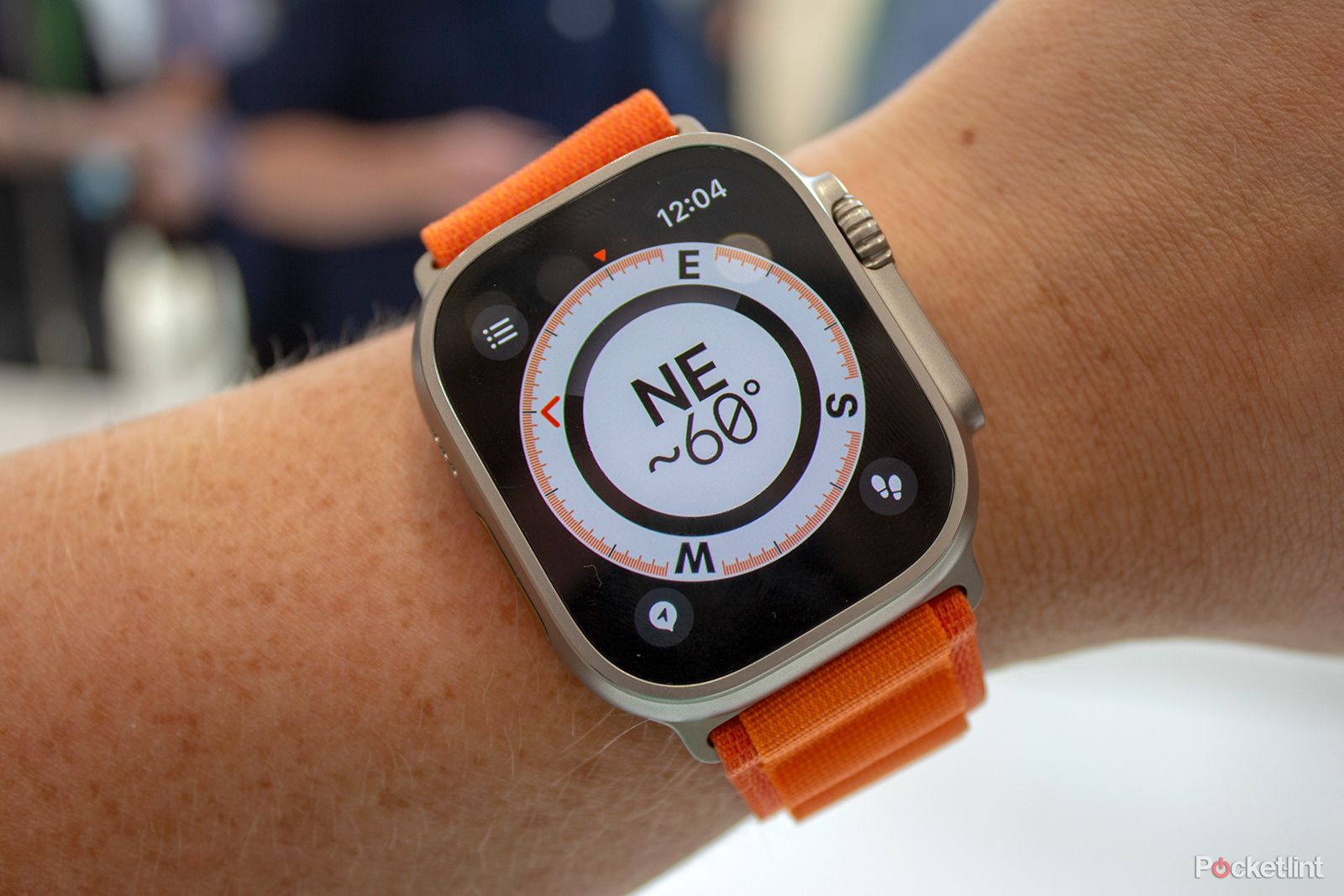 Apple Watch Ultra with orange band on the wrist
