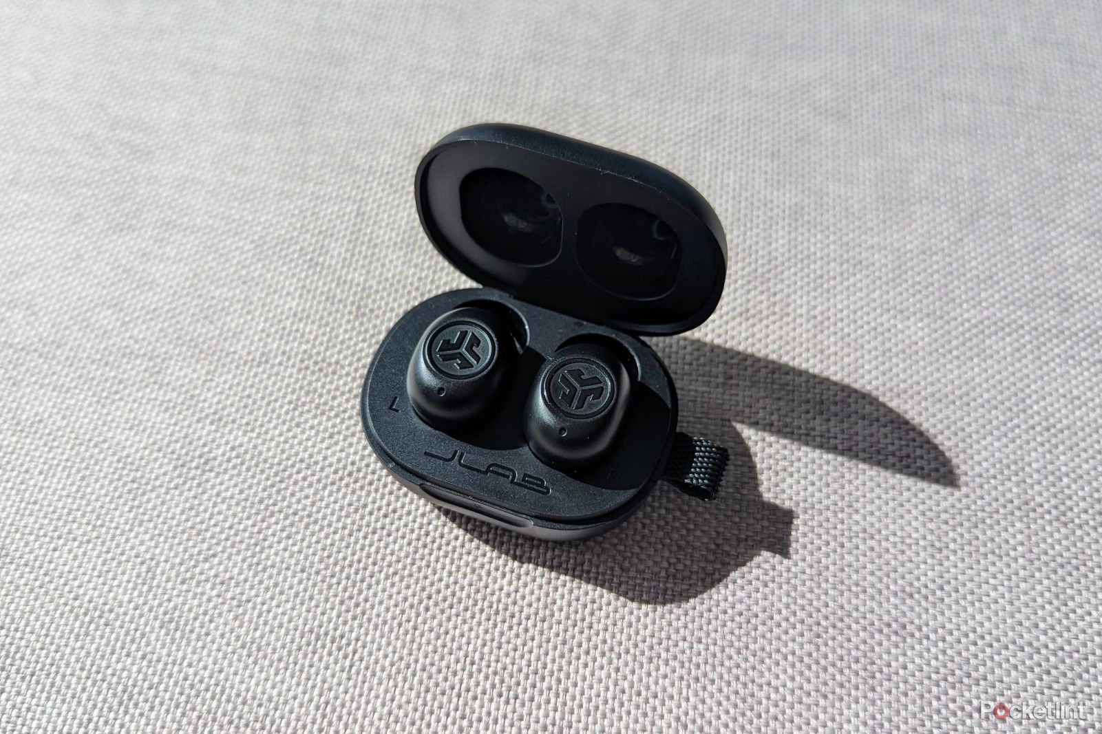 JLab JBuds Mini in case on a cushion