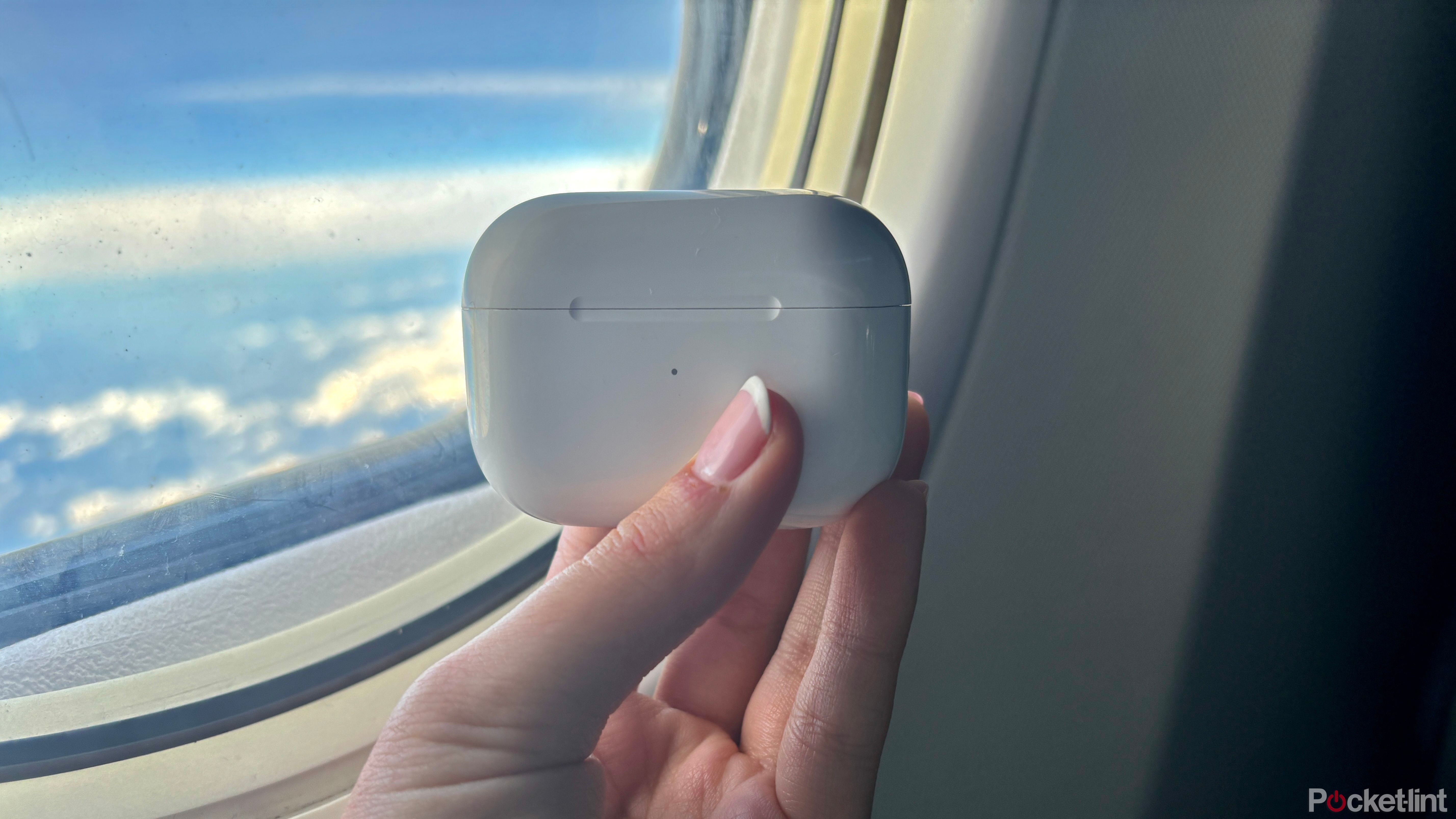 AirPods next to an airplane window