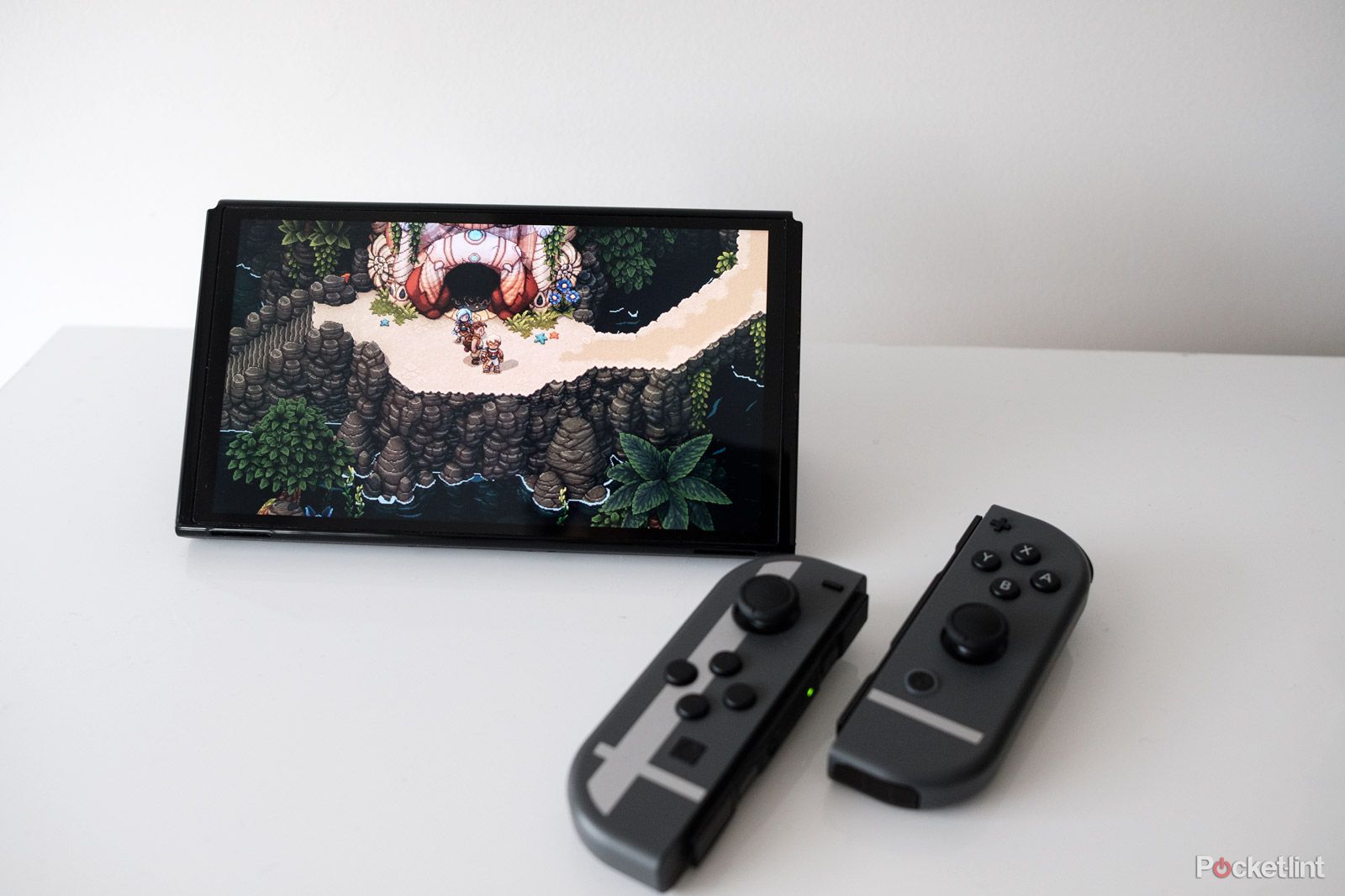 A Nintendo Switch OLED with Sea of Stars on the screen. The Joy-Con controllers are detached from the console.