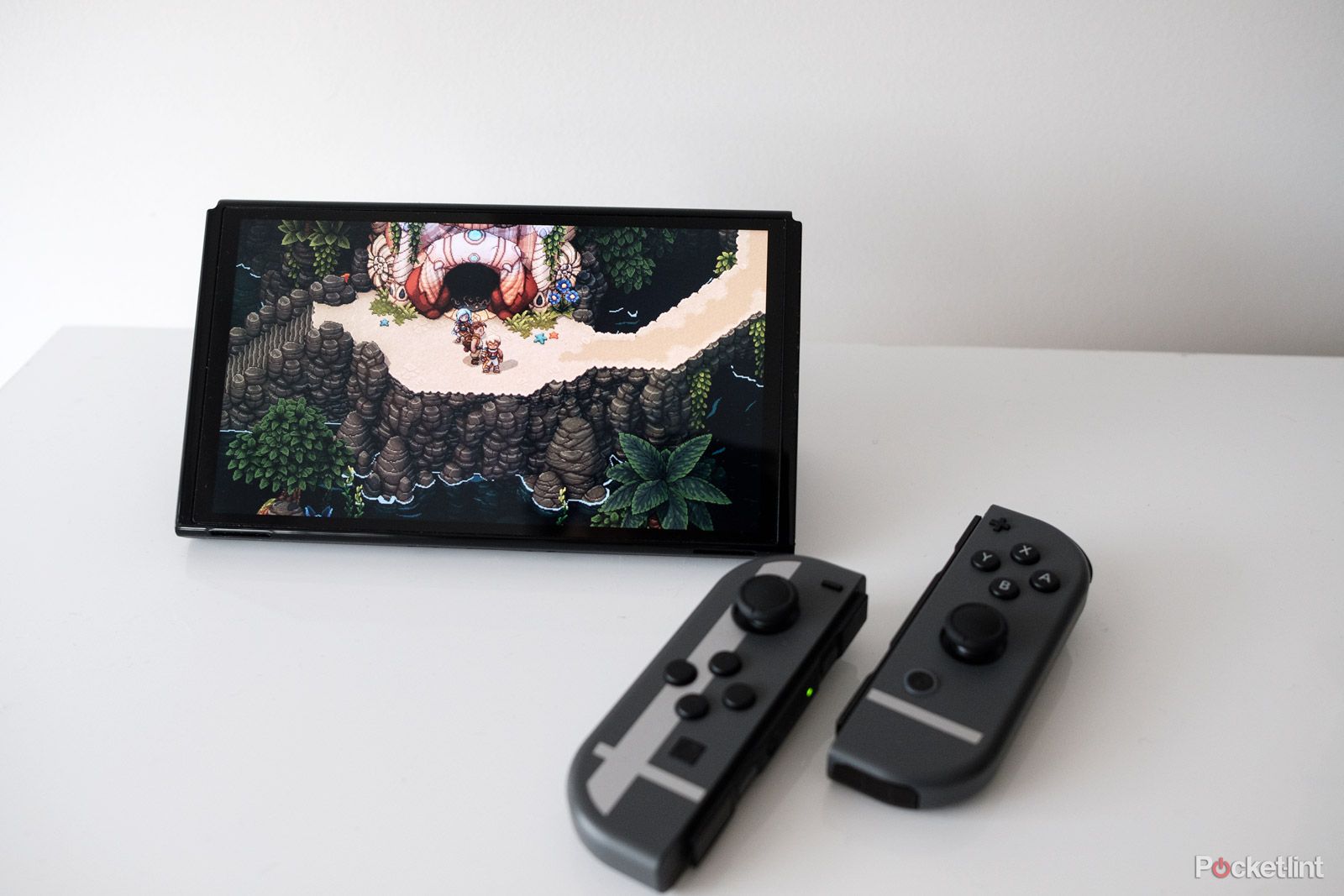 Une Nintendo Switch OLED avec Sea of ​​Stars à l’écran.  Les contrôleurs Joy-Con sont détachés de la console.