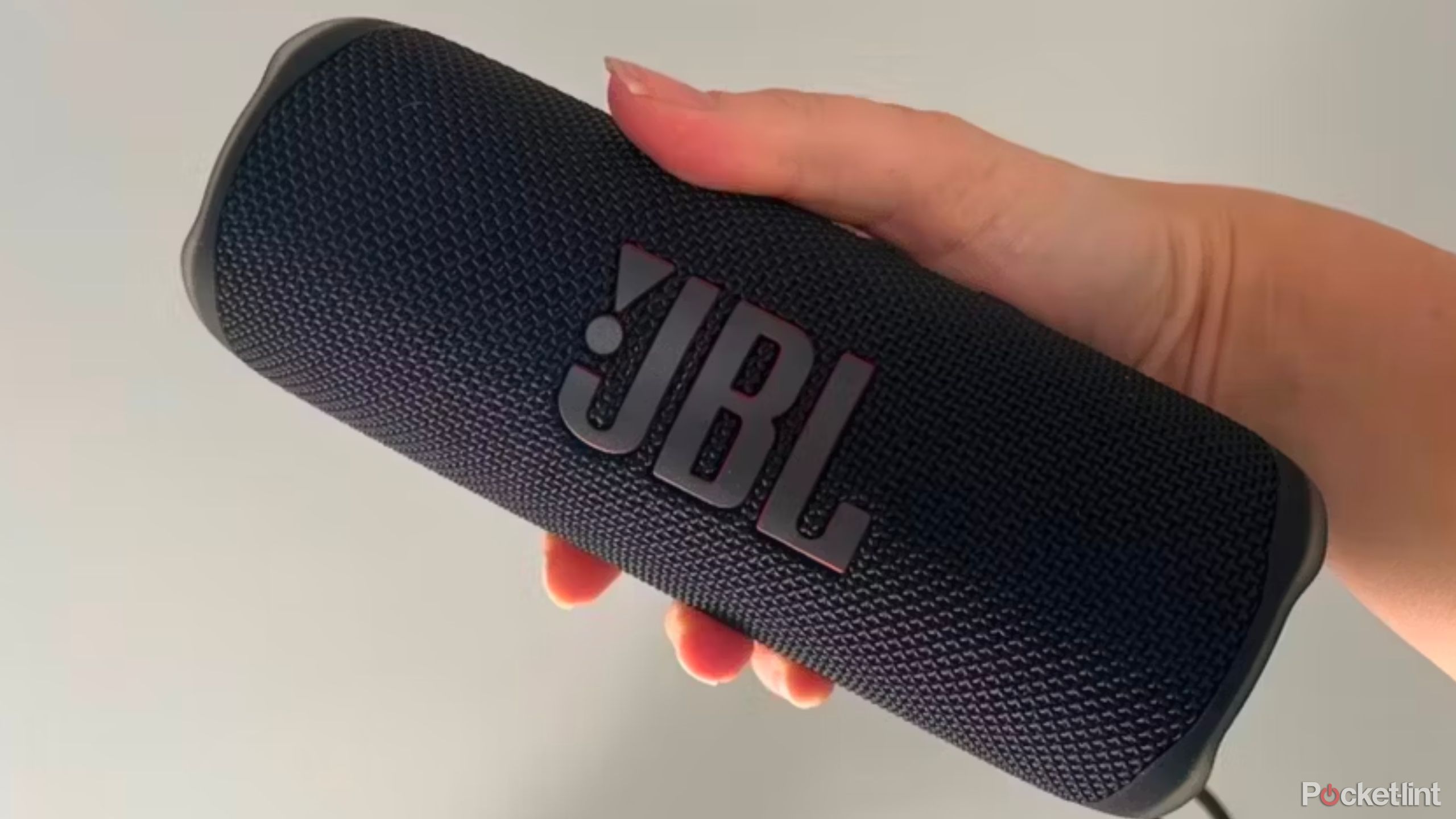 A person holding the JBL Flip 6 in black 