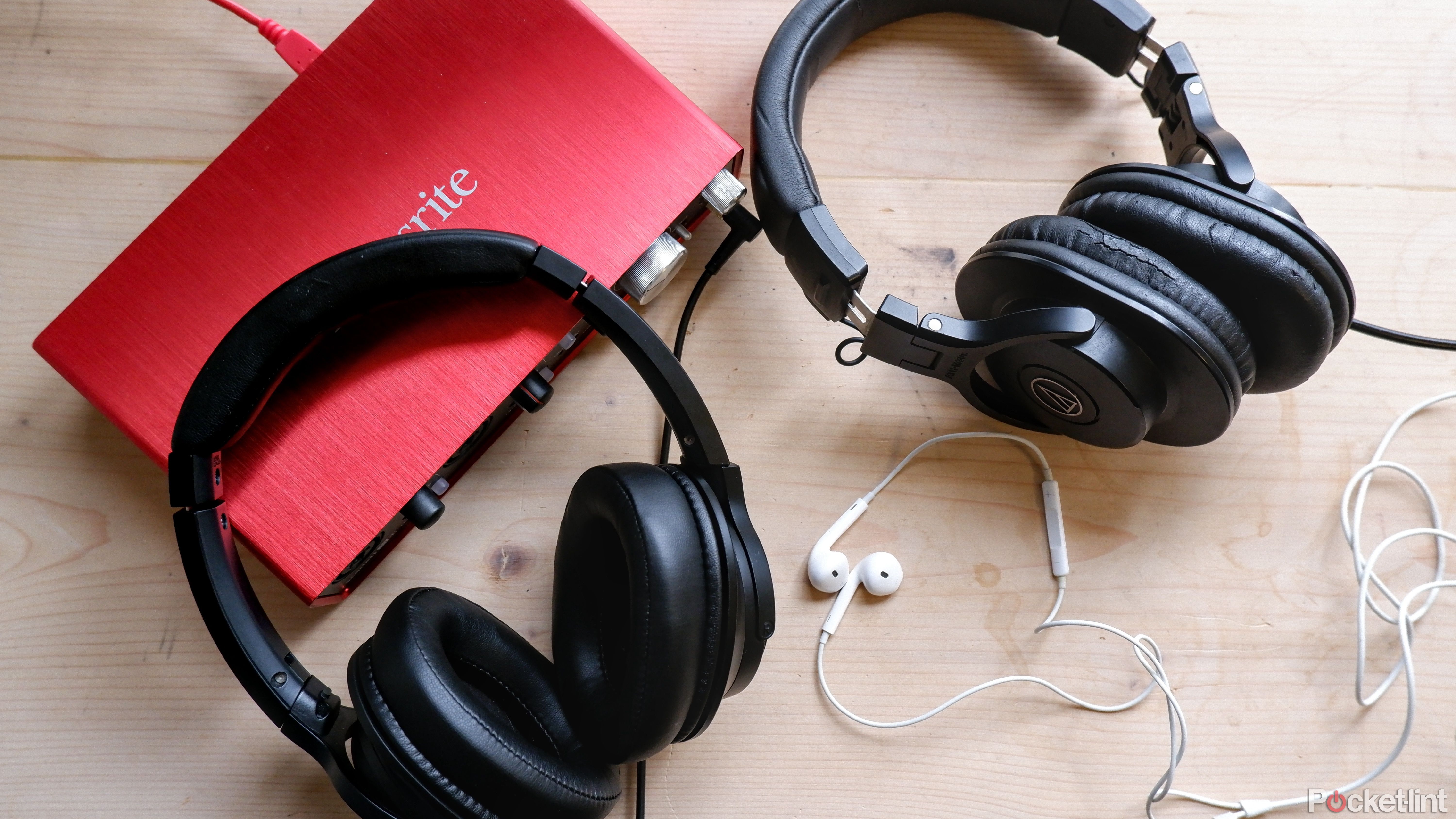 The wired headphones are located on the table next to the Focusrite audio interface.