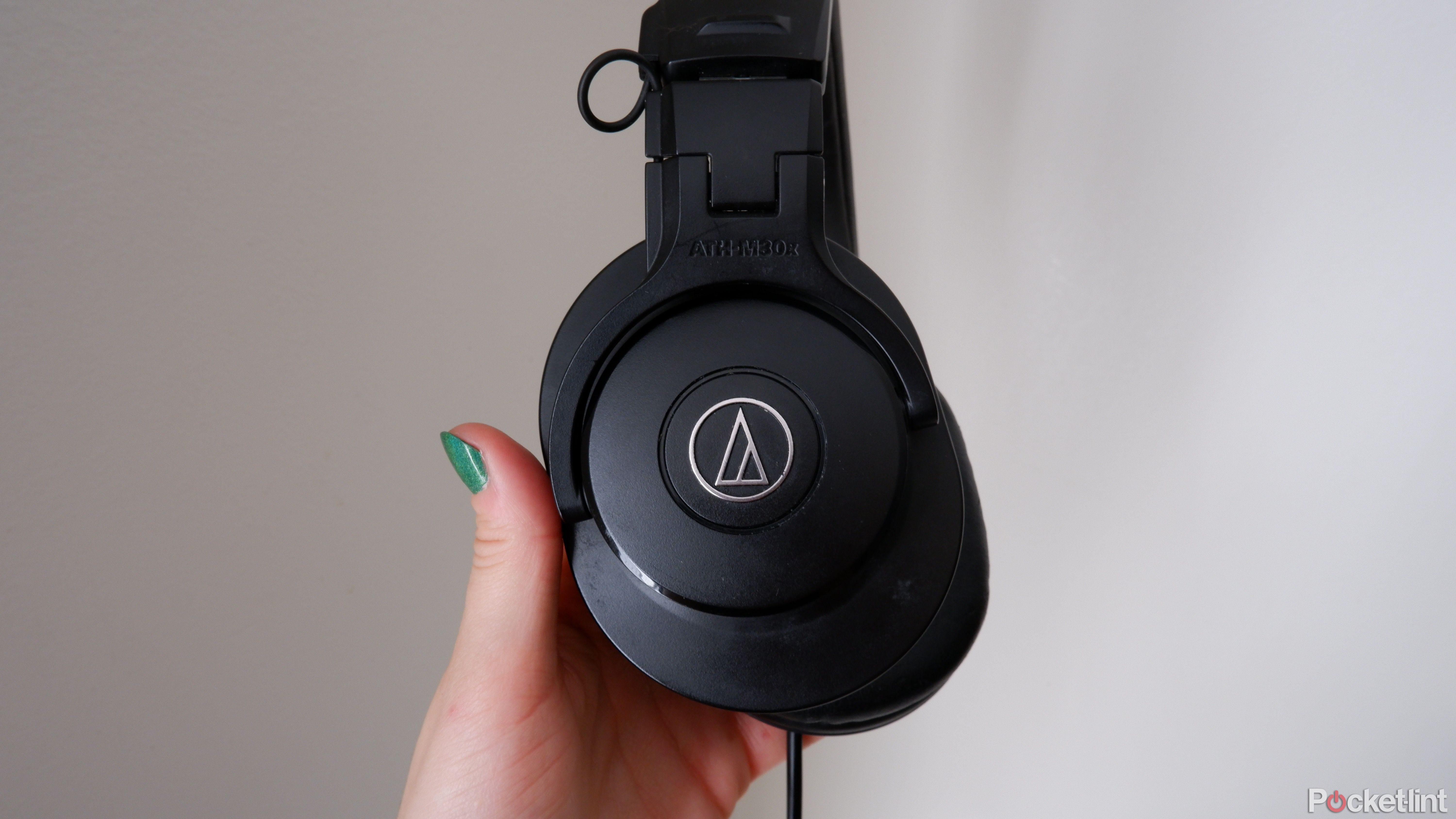 The Audio-Technica ATH-M30x being held by a hand with the logo showing