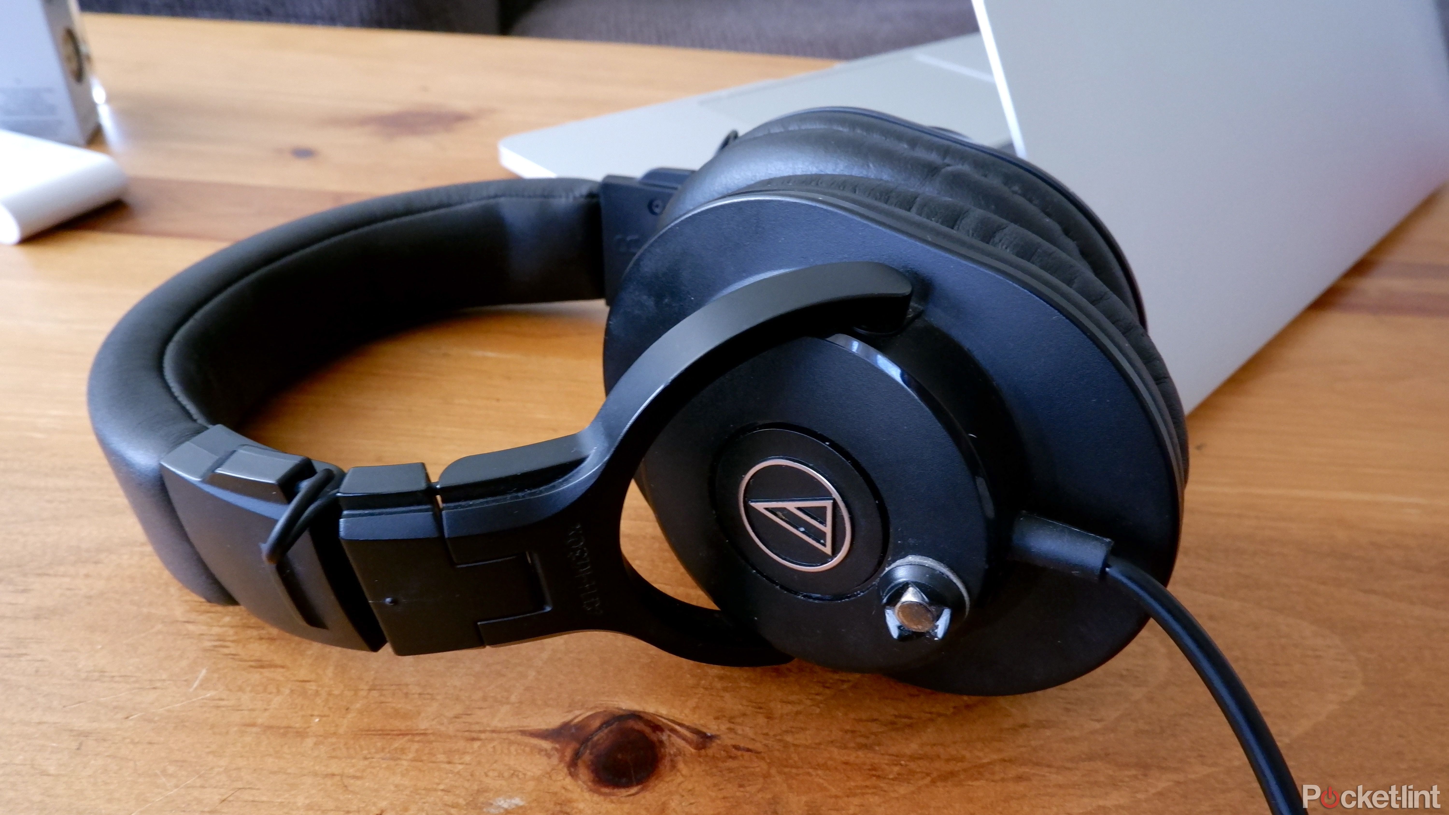 The Audio-Technica ATH-M30x on a coffee table in front of a Macbook Pro
