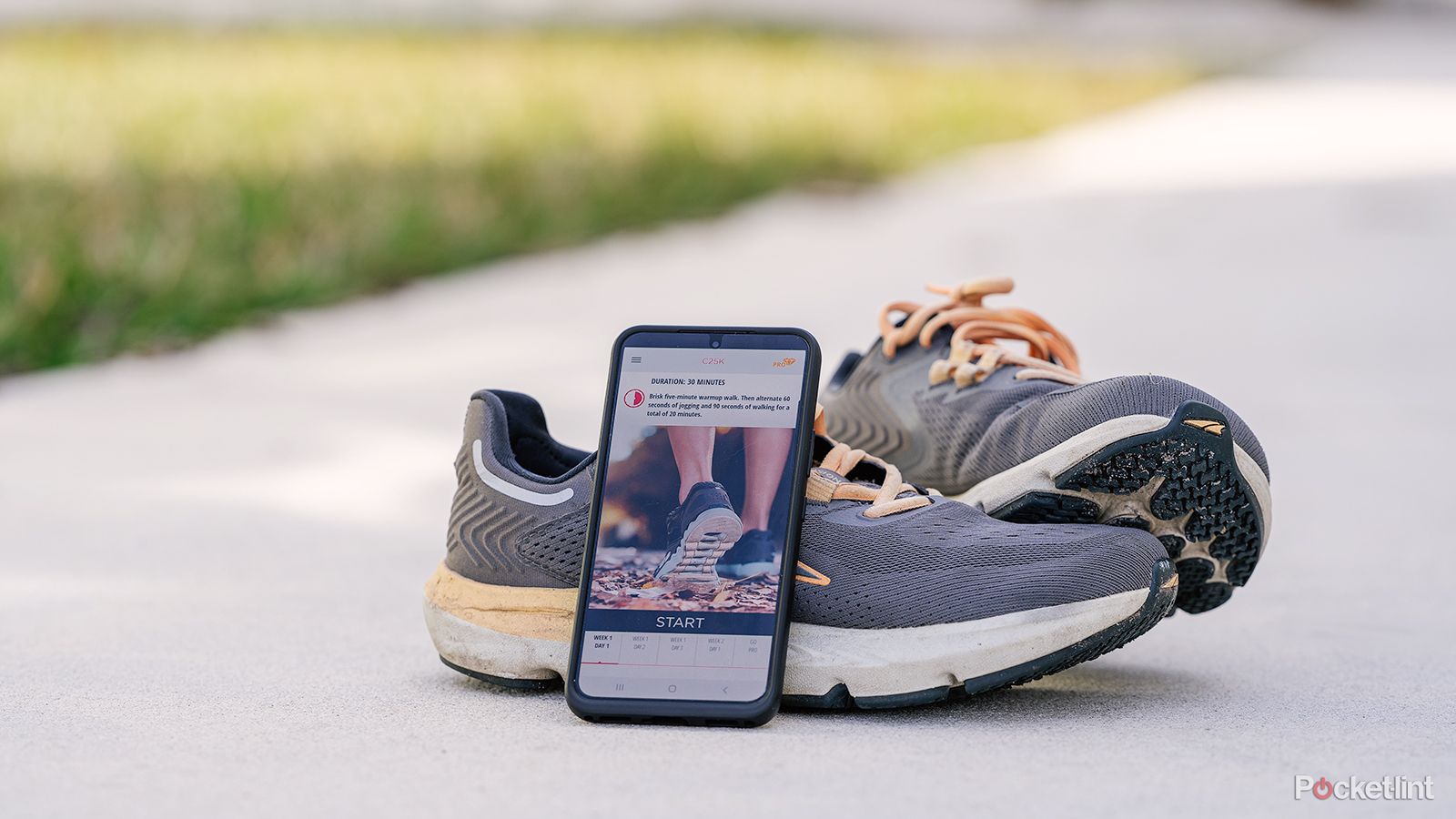 An Android phone sits on a pair of running shoes