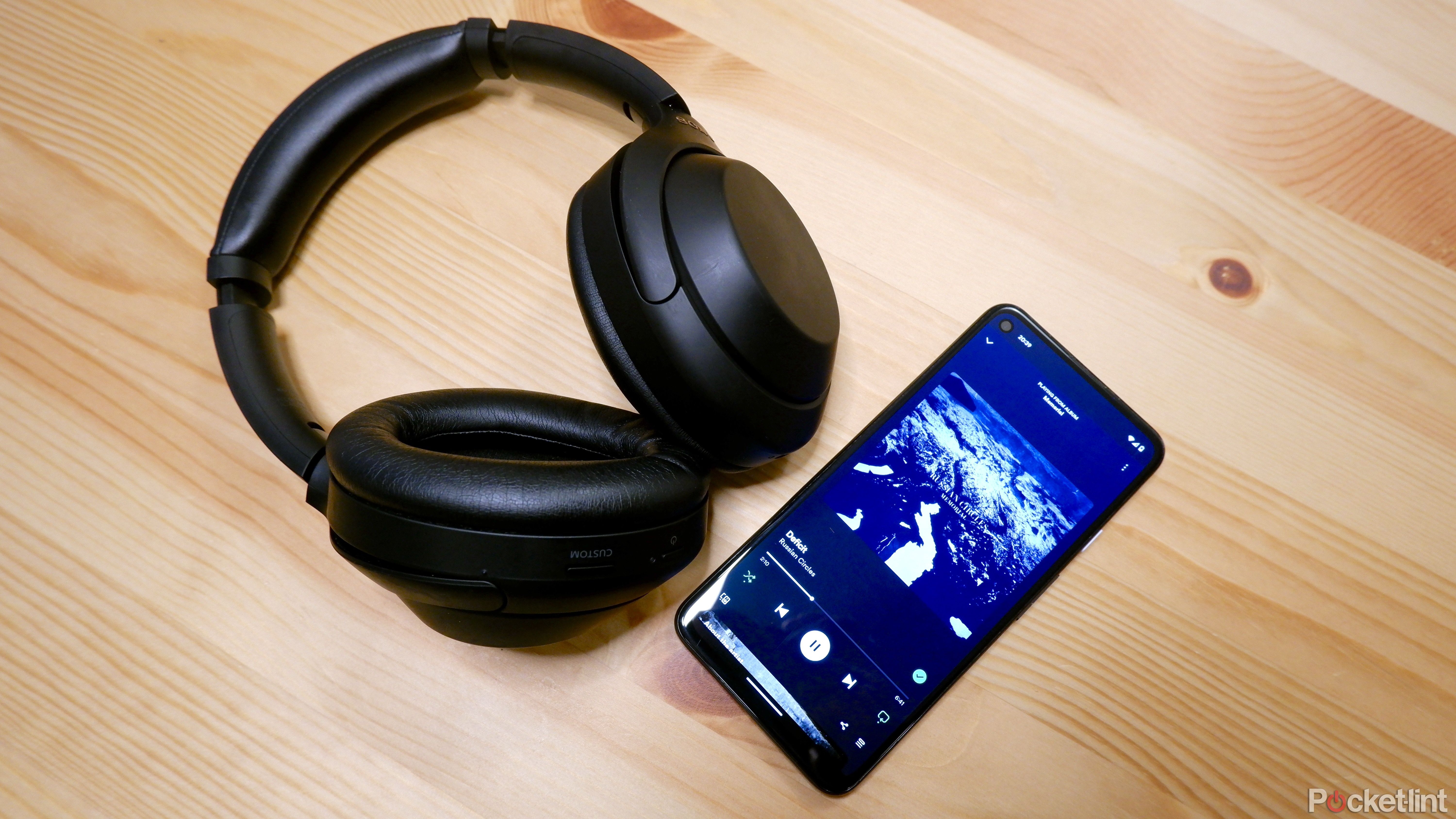 A Pixel with Spotify open next to a pair of Sony WH-1000XM4