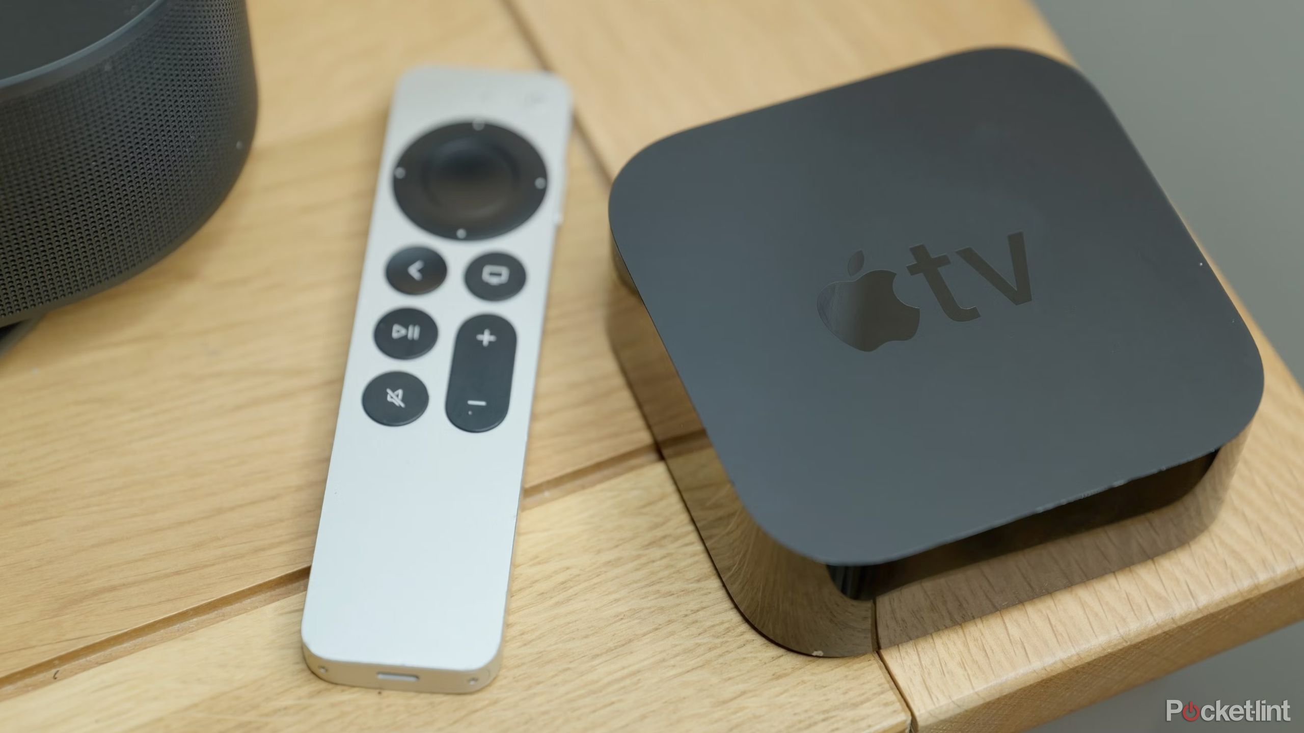 یک Apple TV 4K و یک کنترل از راه دور سیری روی میز.