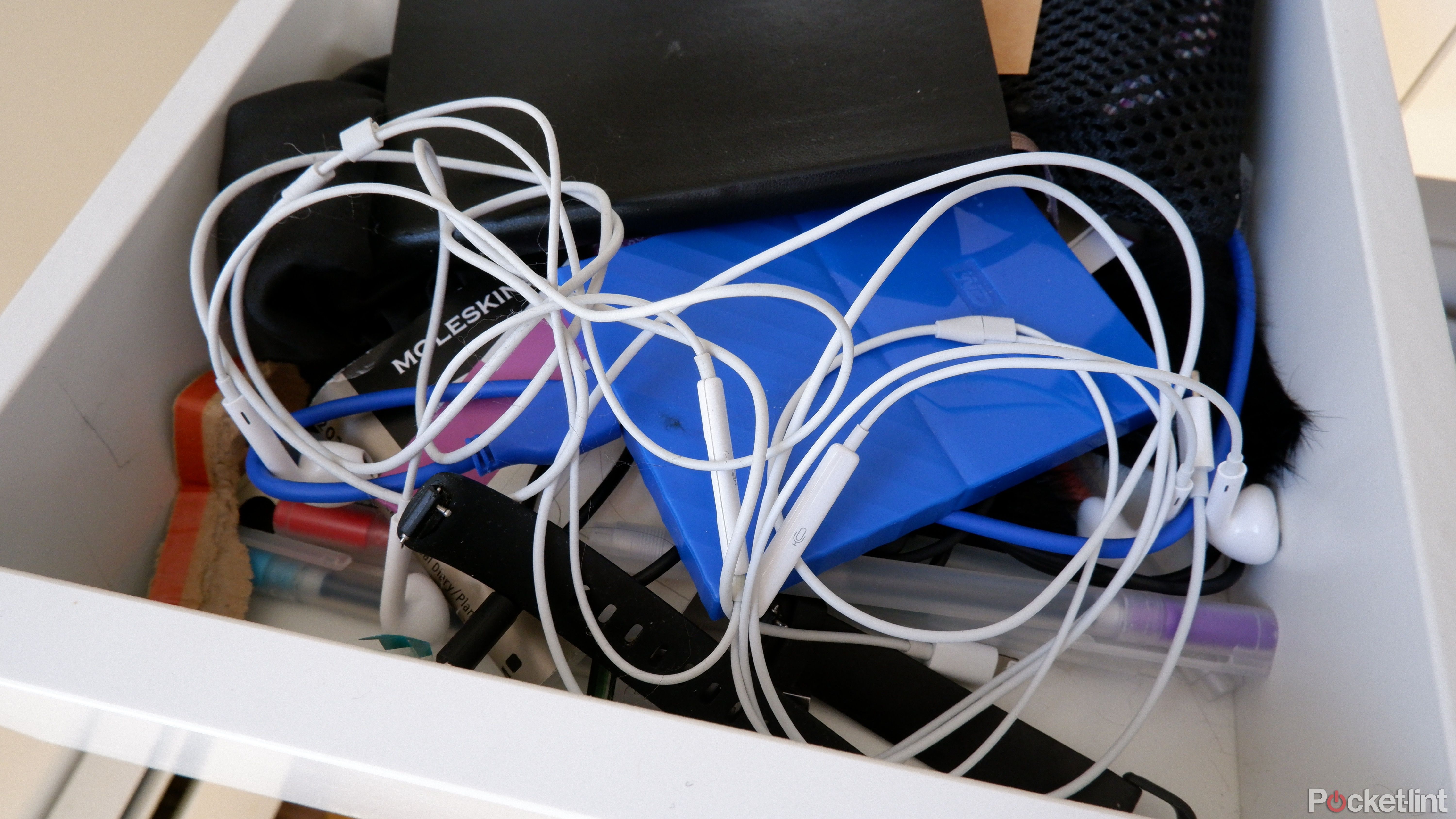Two pairs of EarPods in a junk drawer