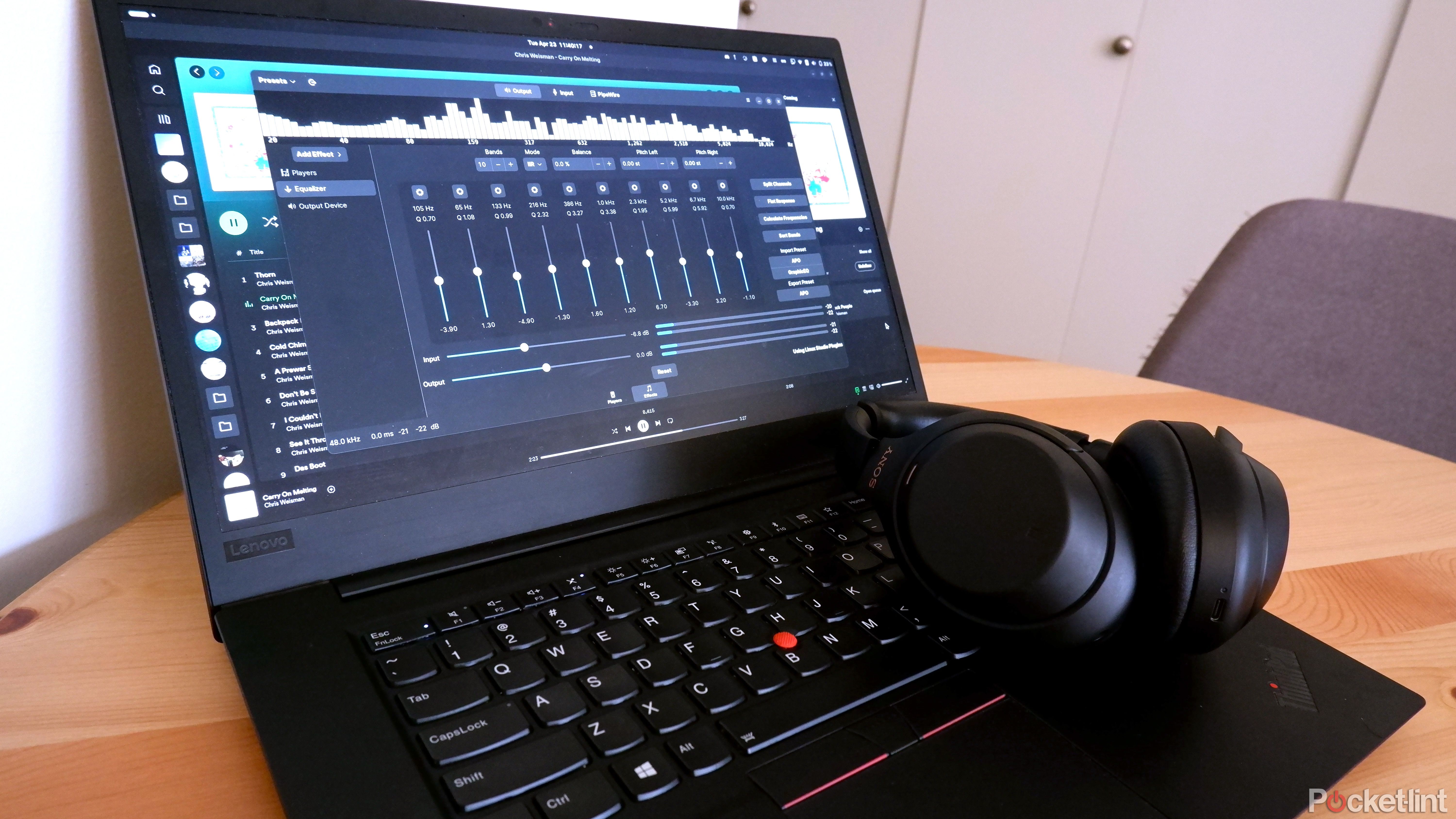 ThinkPad with an equalizer app open, with Sony WH-1000XM4 resting on the laptop