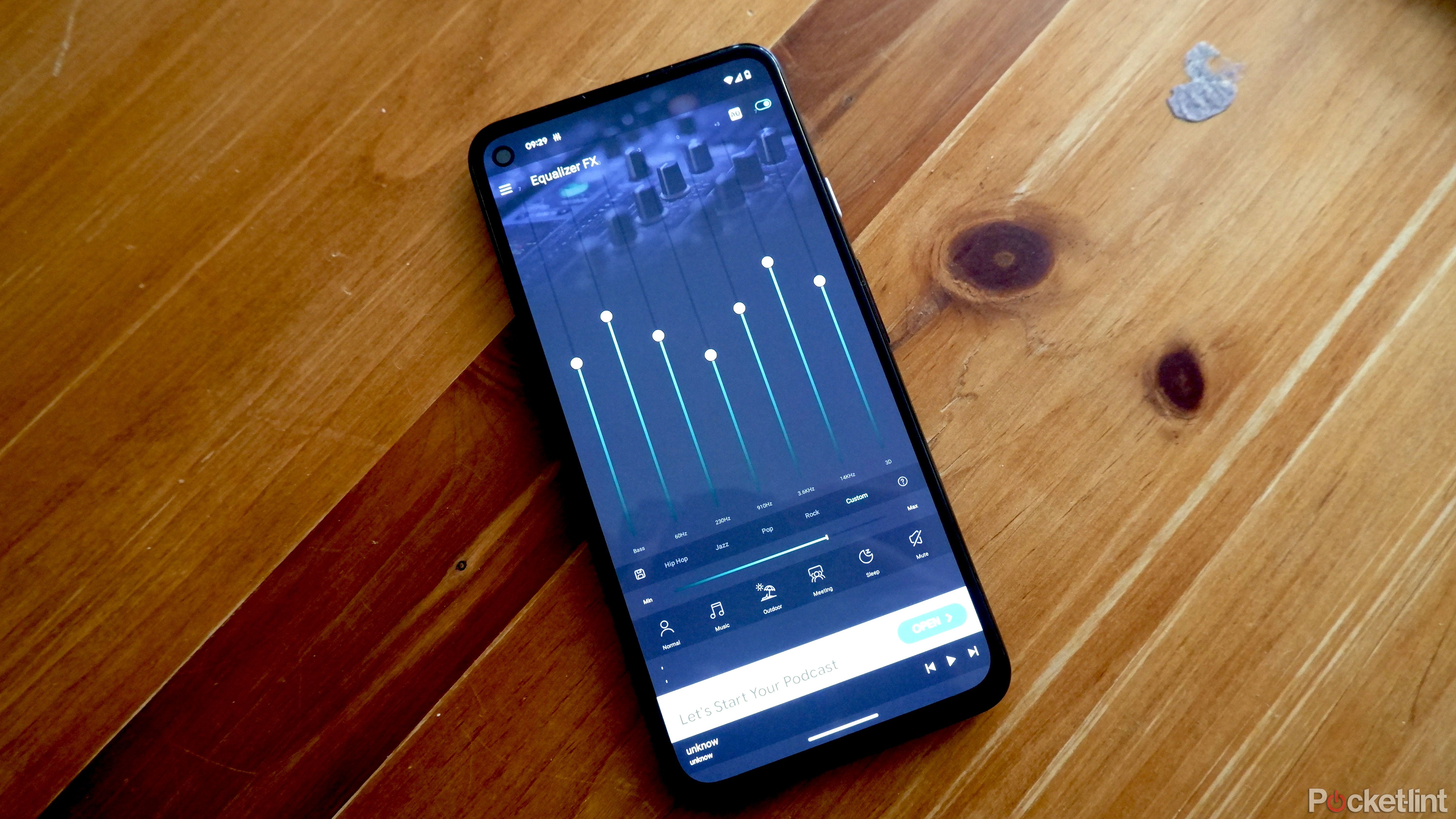 A Google Pixel on a wooden surface with the Equalizer FX app open.