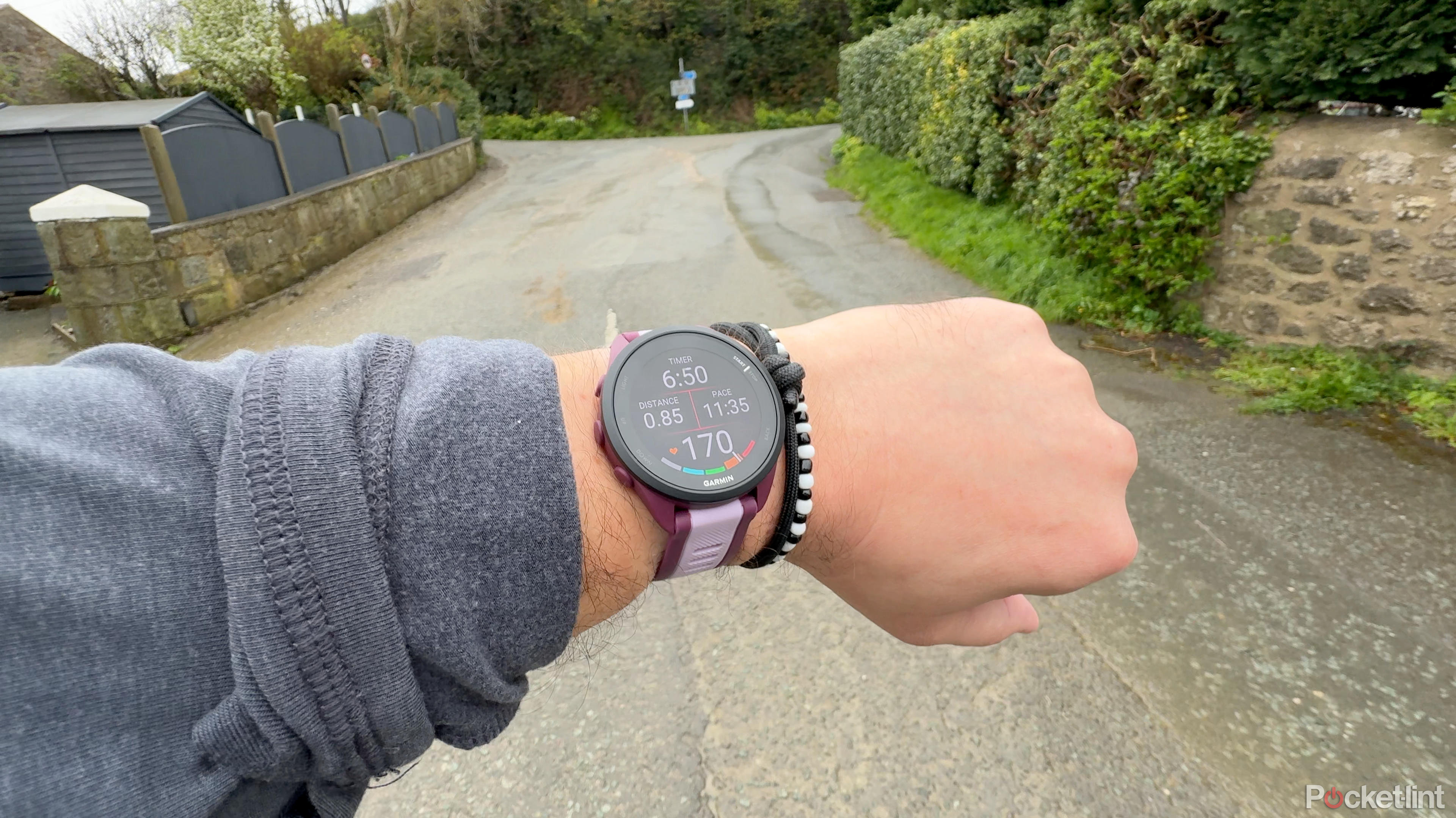 A person runs with the Forerunner 165 along a Welsh country road