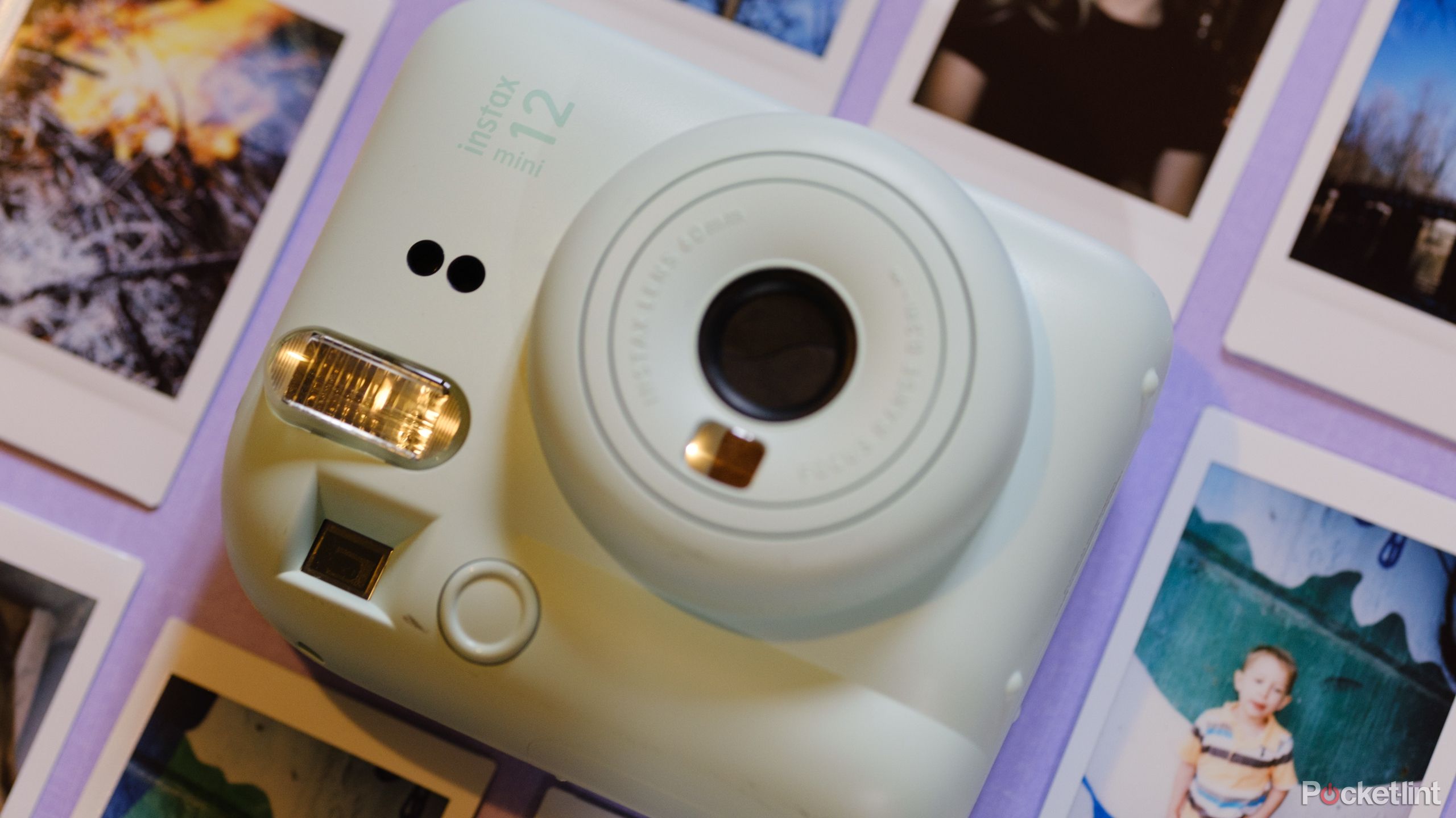 A photo of the Fujifilm Instax Mini 12 with prints