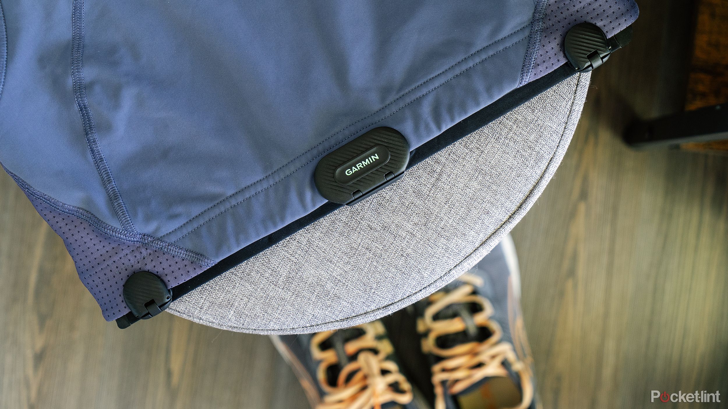 The Garmin HRM-Fit on a sports bra, resting on a stool above shoes. 