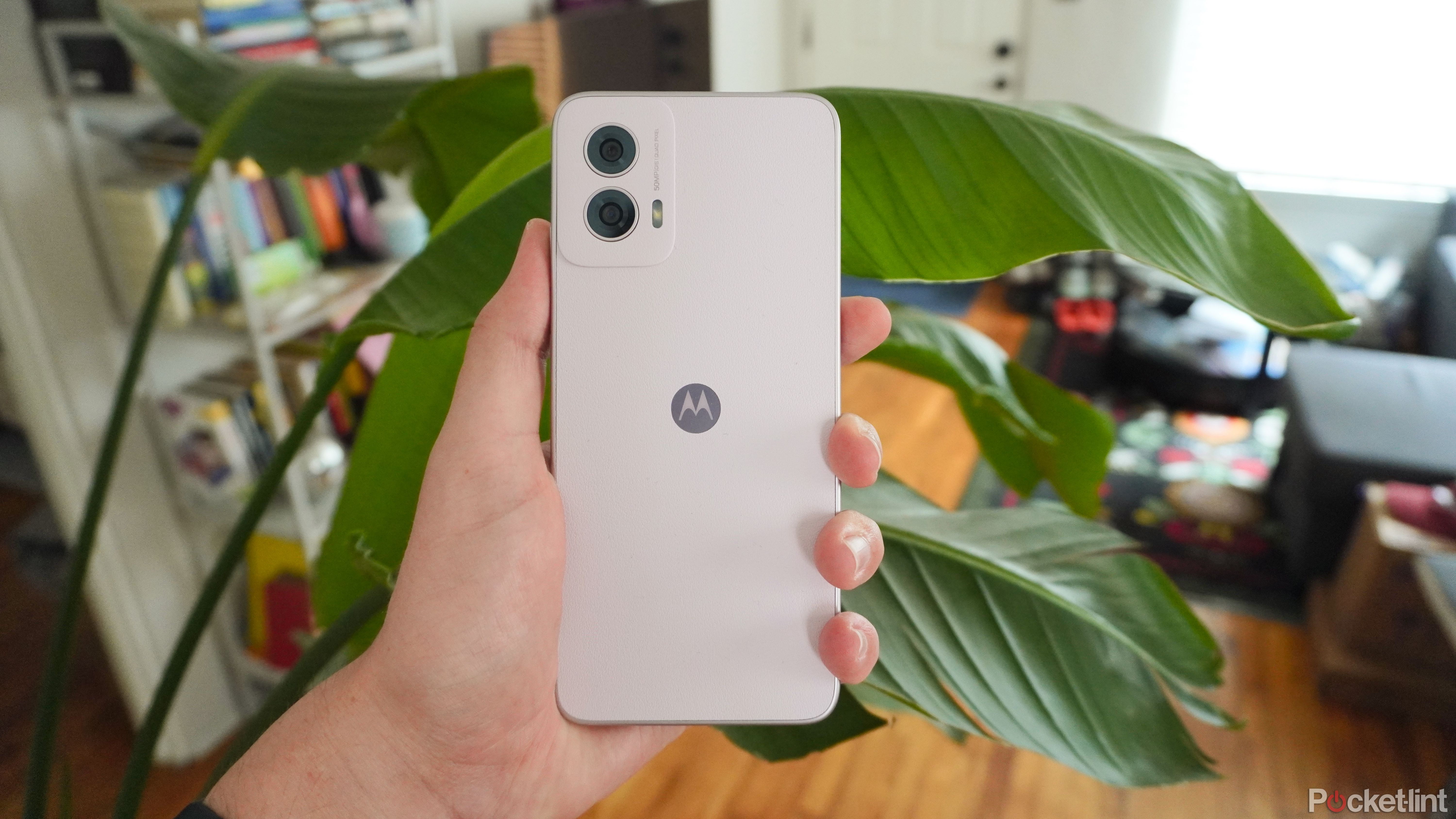 The lilac Moto G Power 5G's back held in front of a green plant.