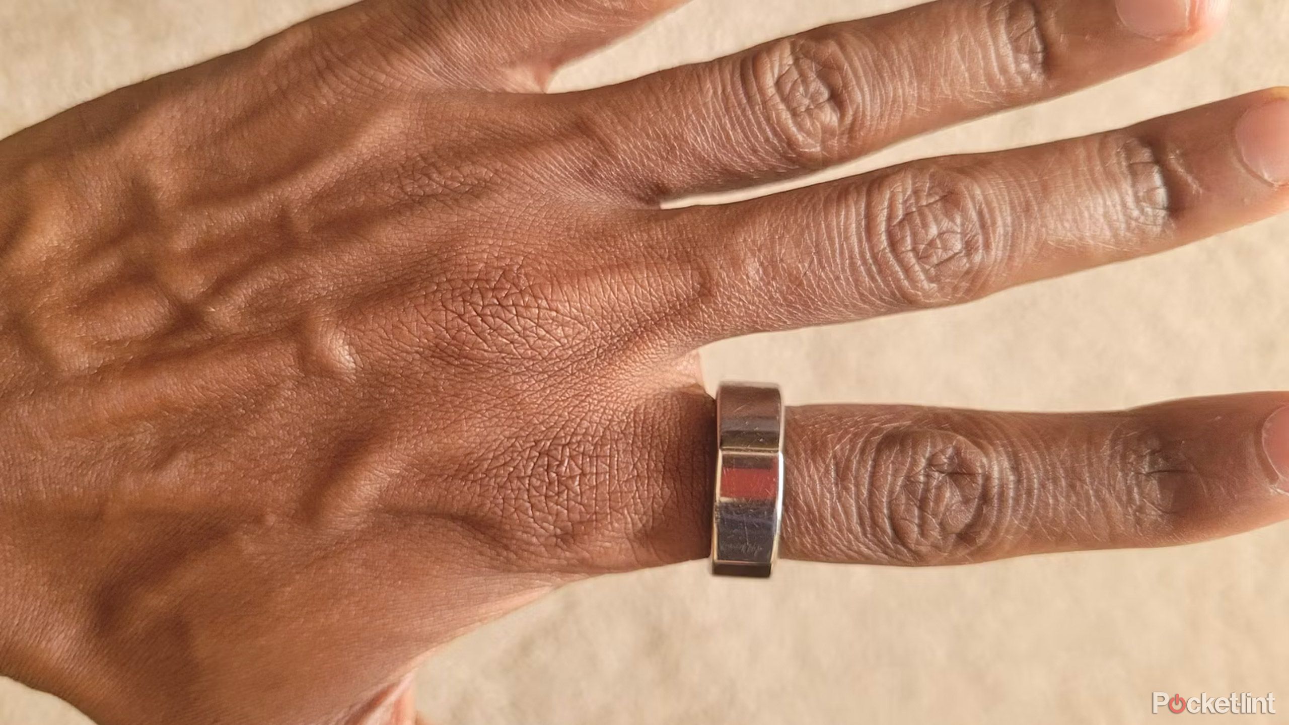 A person wears a Gen 3 Oura Ring on their index finger. 