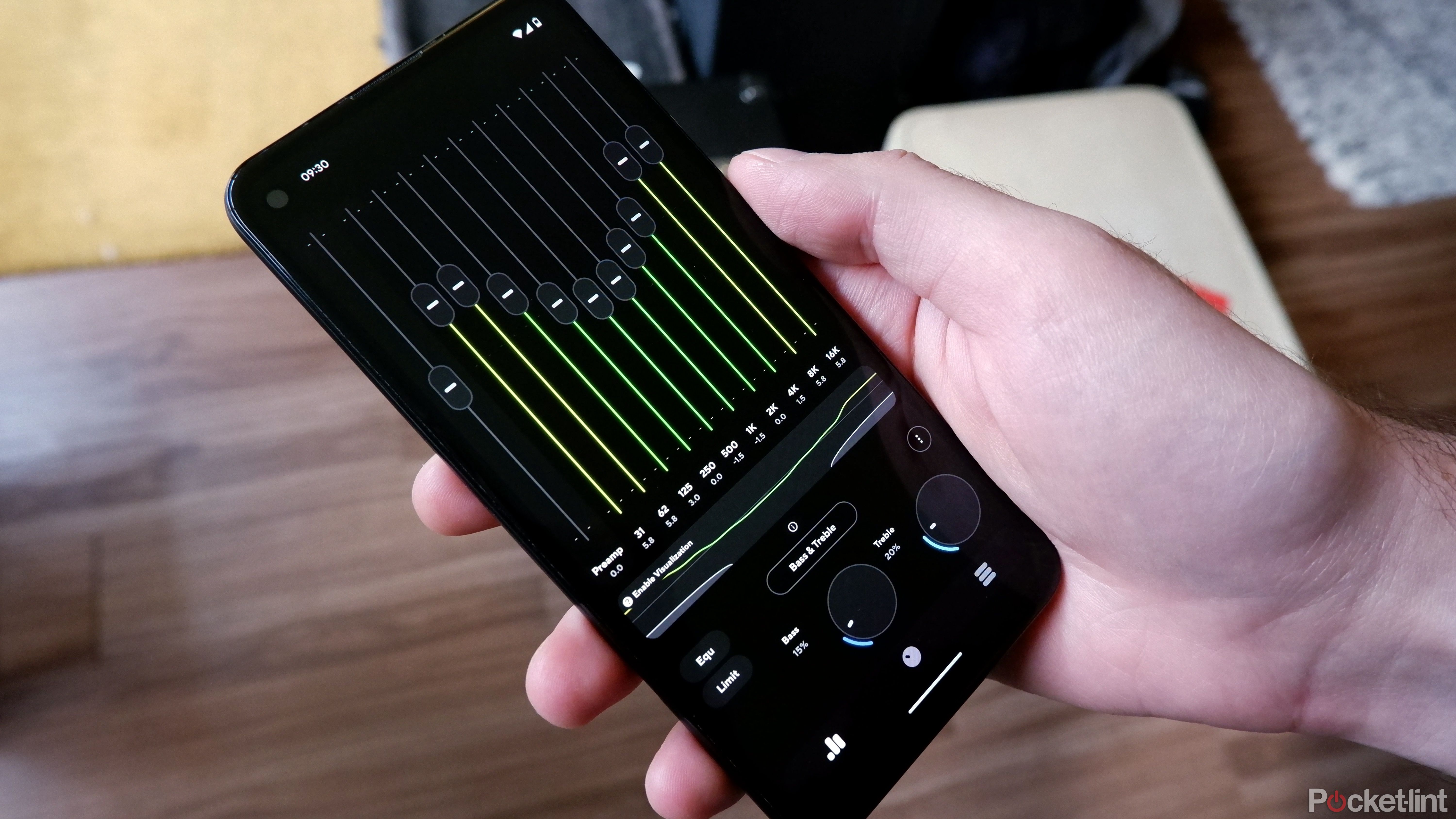 A Google Pixel being held by a hand with the Poweramp Equalizer app open.