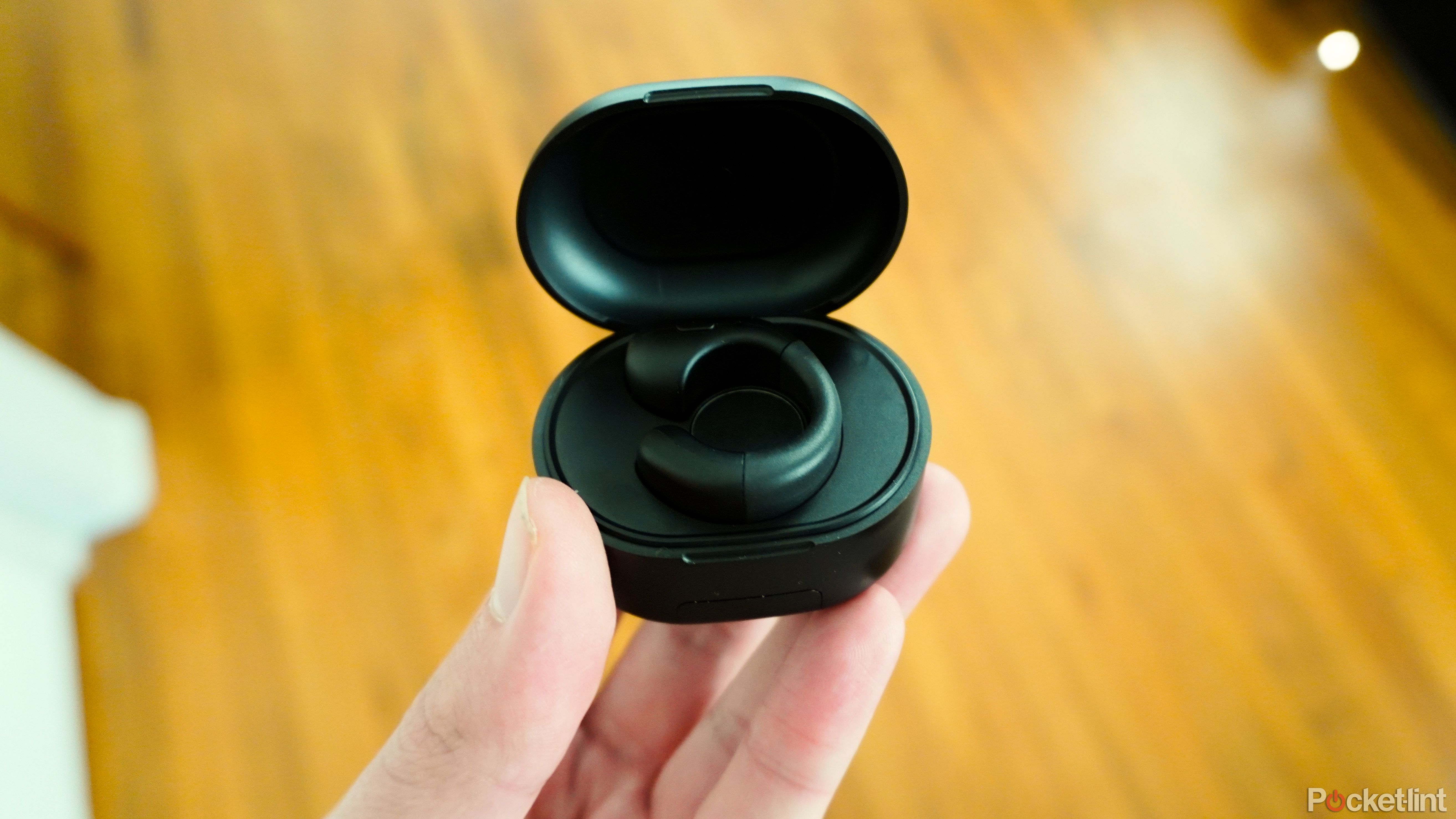 A ring-shaped remote sitting in a charging case.