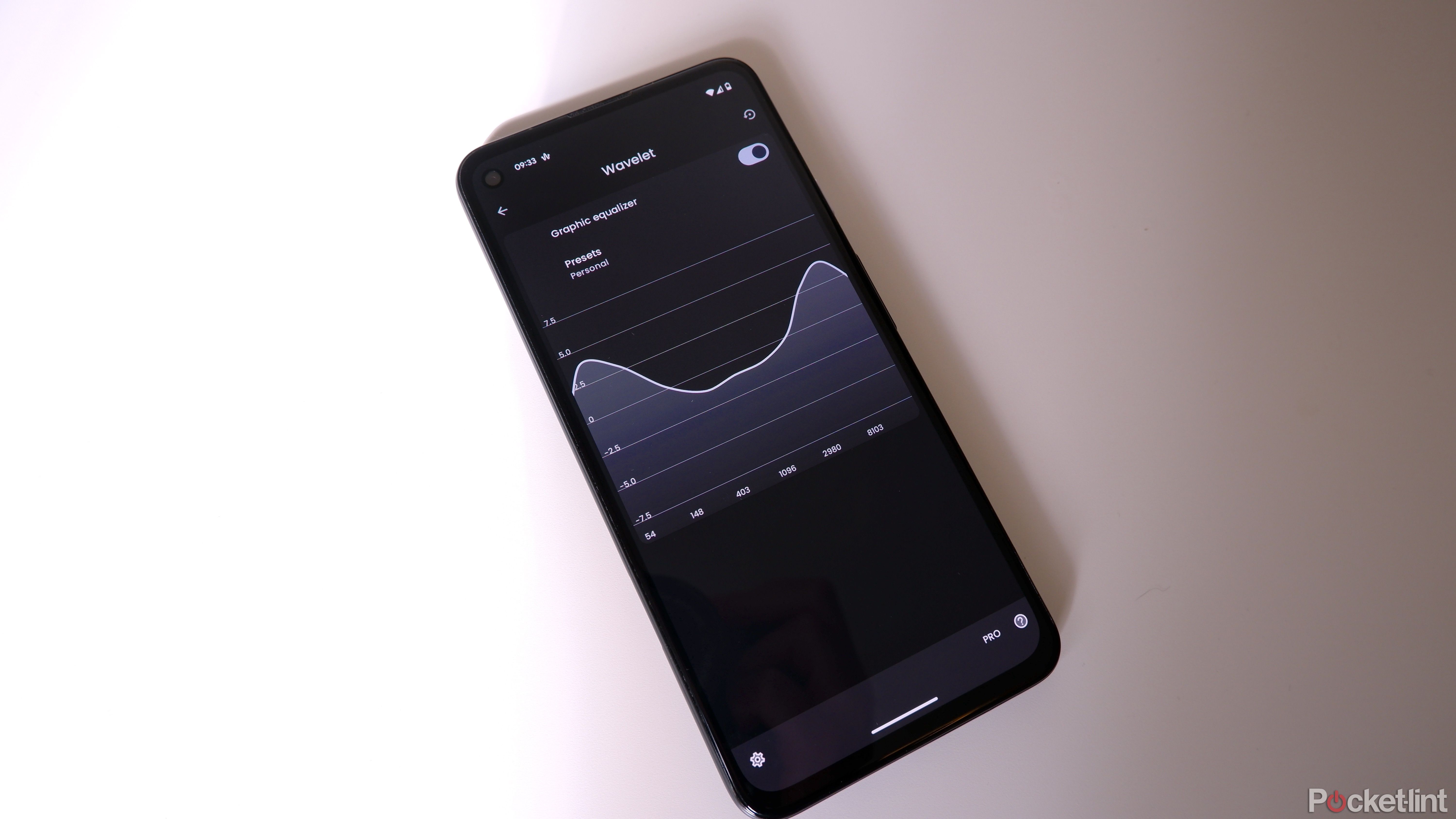 A Google Pixel on a white surface with the Wavelet app open, showing a custom EQ.