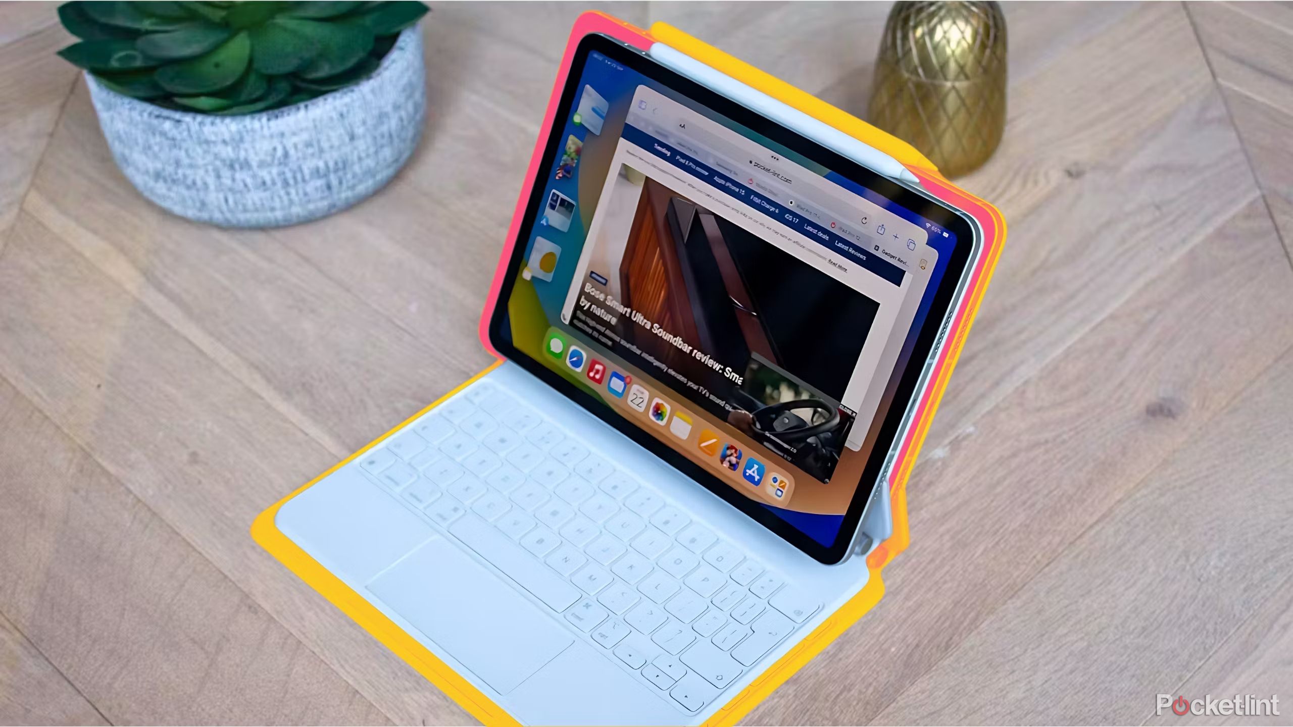 Ipad Pro magic keyboard displayed with succulent and gold pineapple paperweight in background.