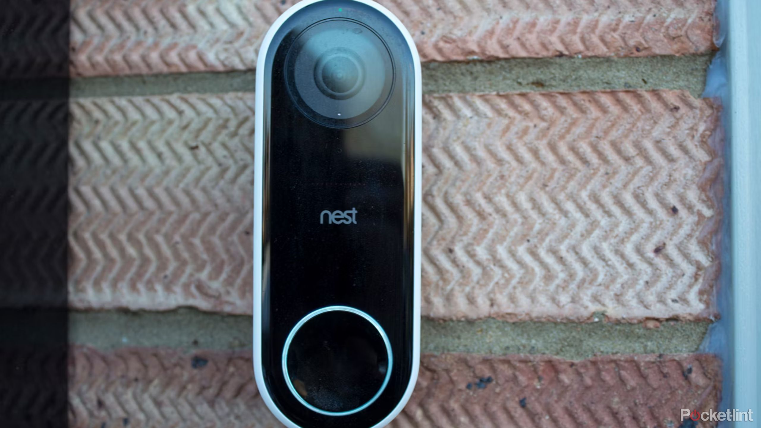Nest Hello in black on a brick wall