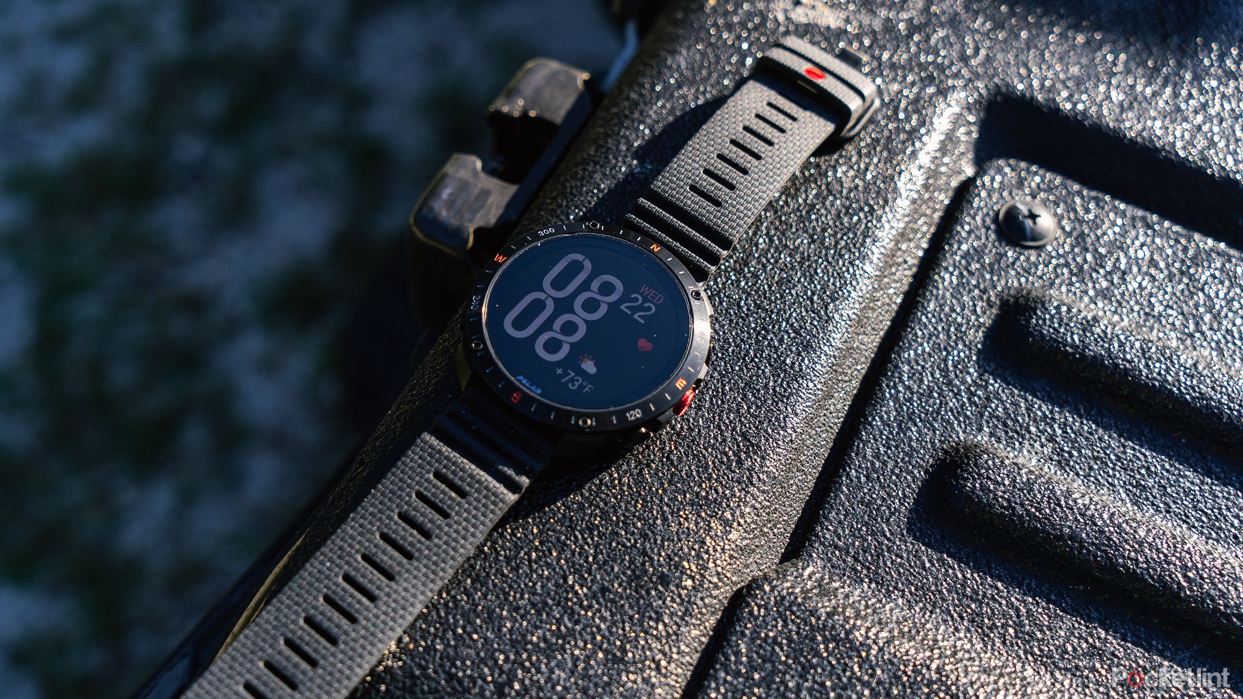 The Polar Grit X2 Pro smartwatch placed on a black truck bed. 