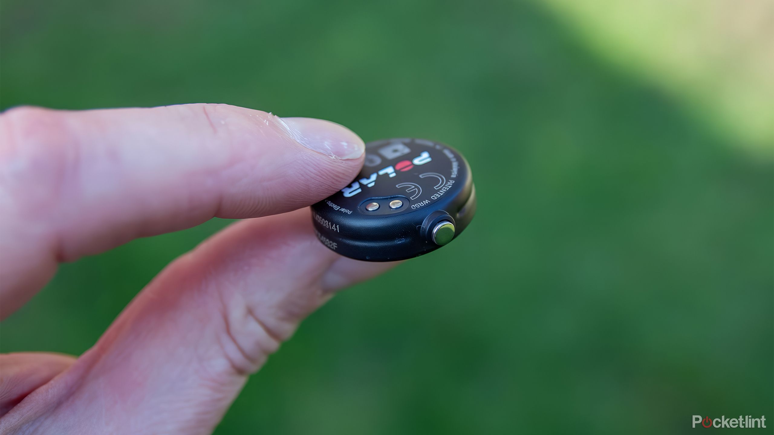 A person holds the Polar Verity heart rate sensor between their fingers