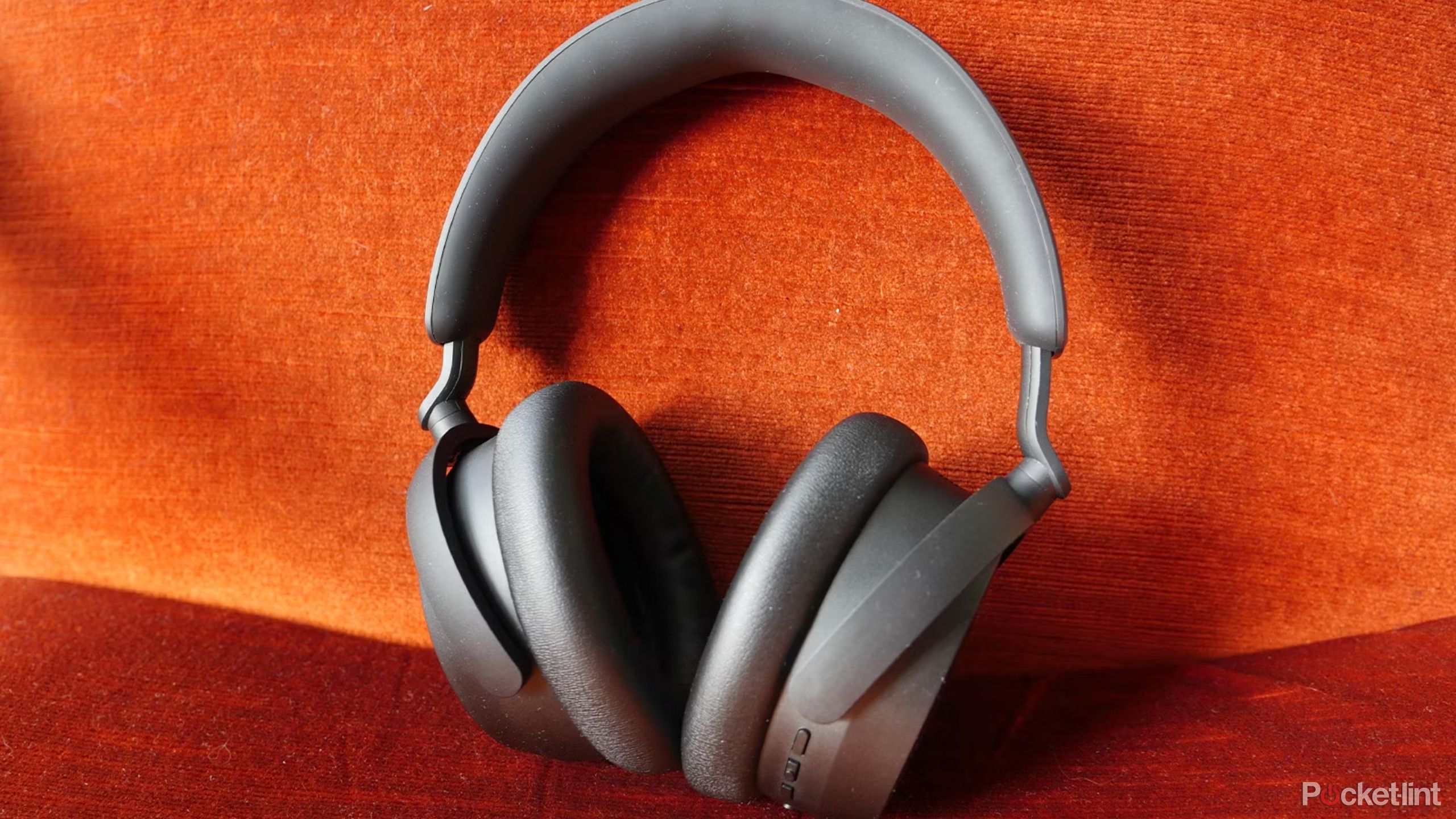 Sennheiser Accentum 2 headphones against an orange sofa.