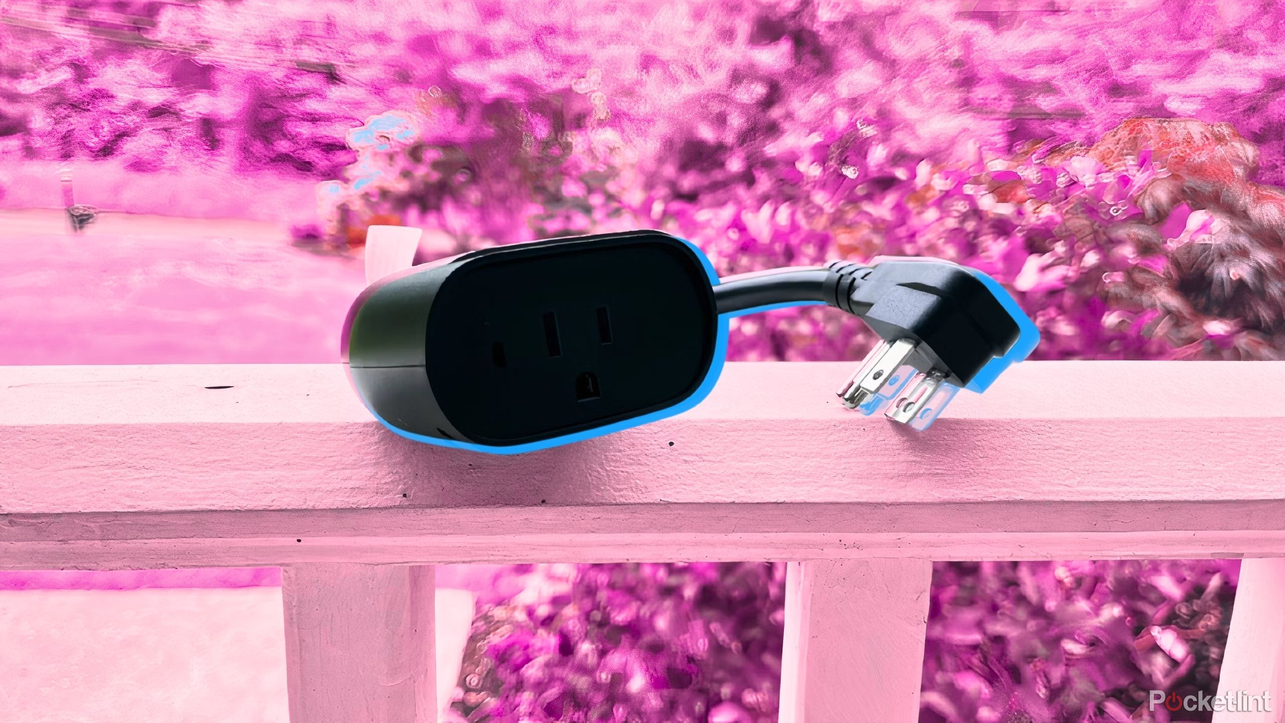 The Kasa Outdoor Smart Plug sits on a white railing