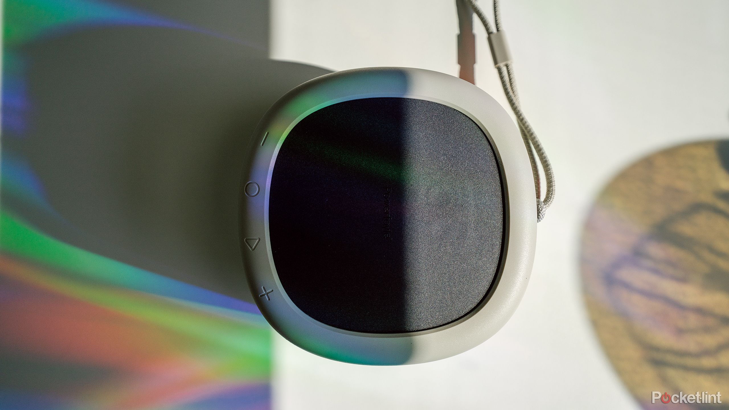 The Urbanista Malibu speaker on a white desk with rainbow light cast on it. 