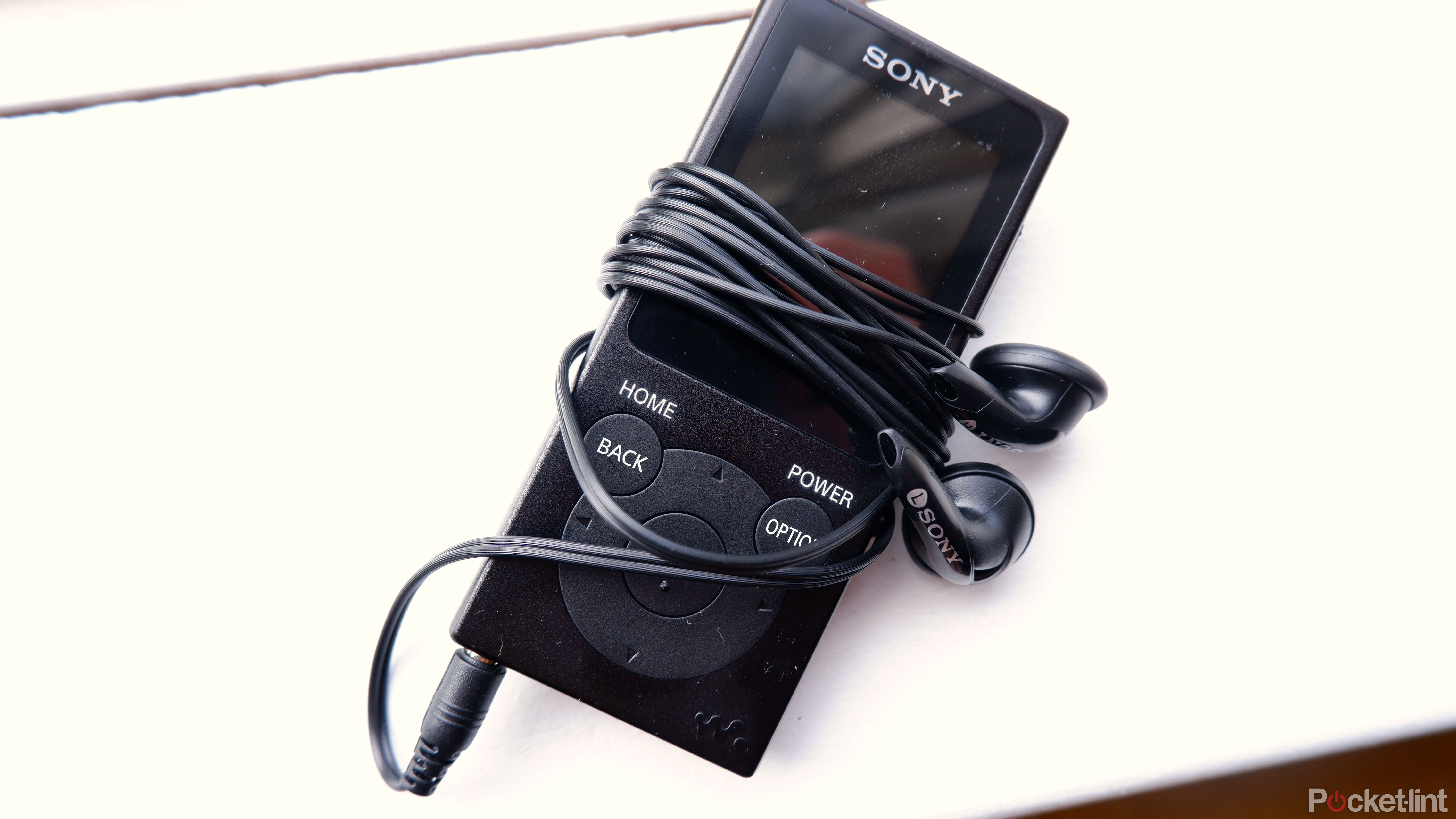 A Sony Walkman wrapped with the earbuds the Walkman comes with.