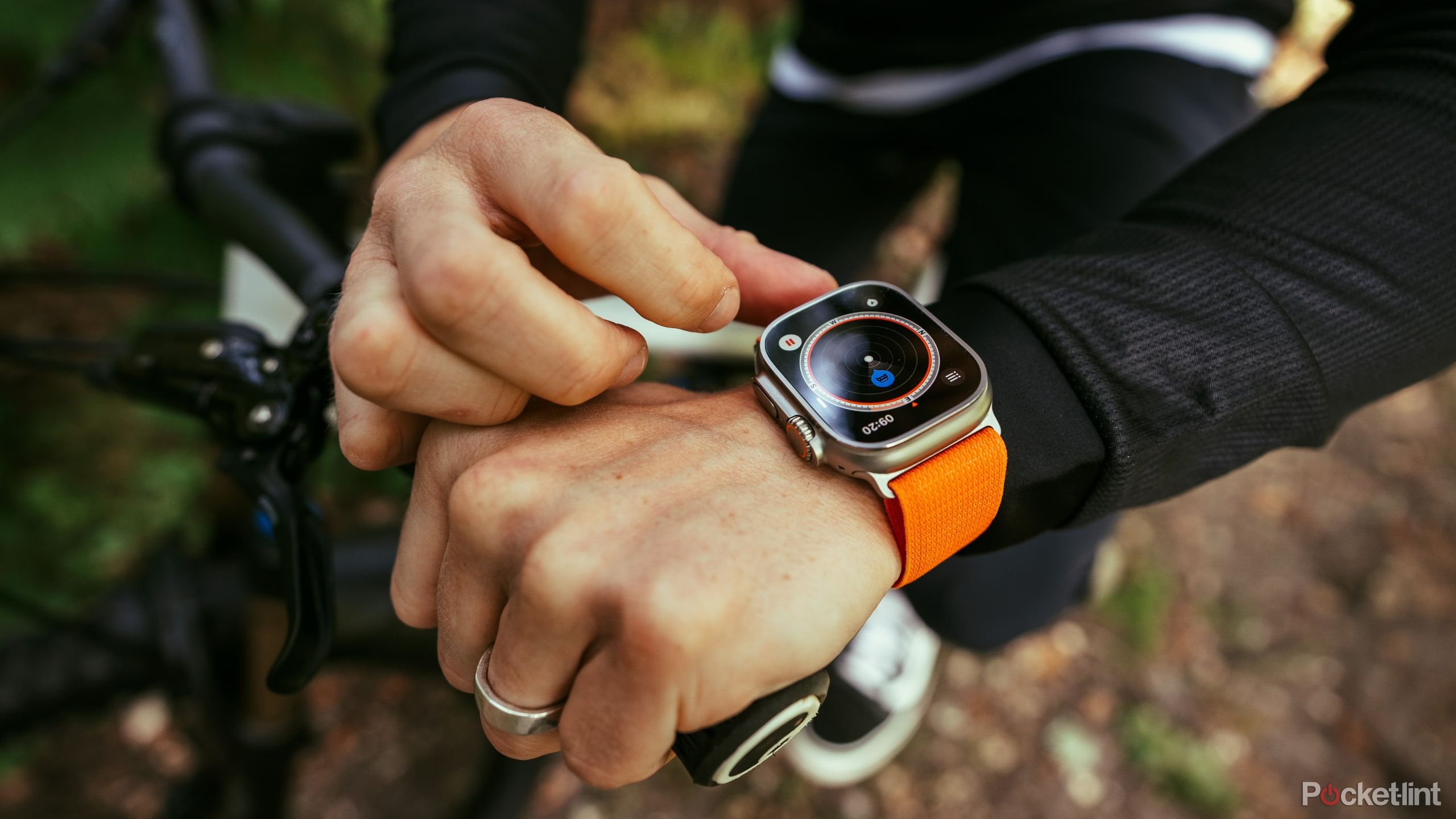 Apple Watch Ultra Flatout being worn on a bike on a trail. 