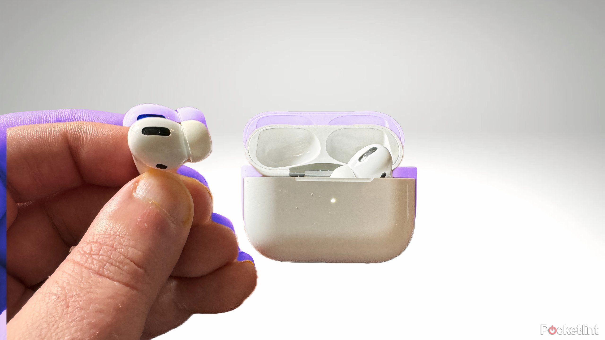apple airpods being held and demonstrating the pinch gesture