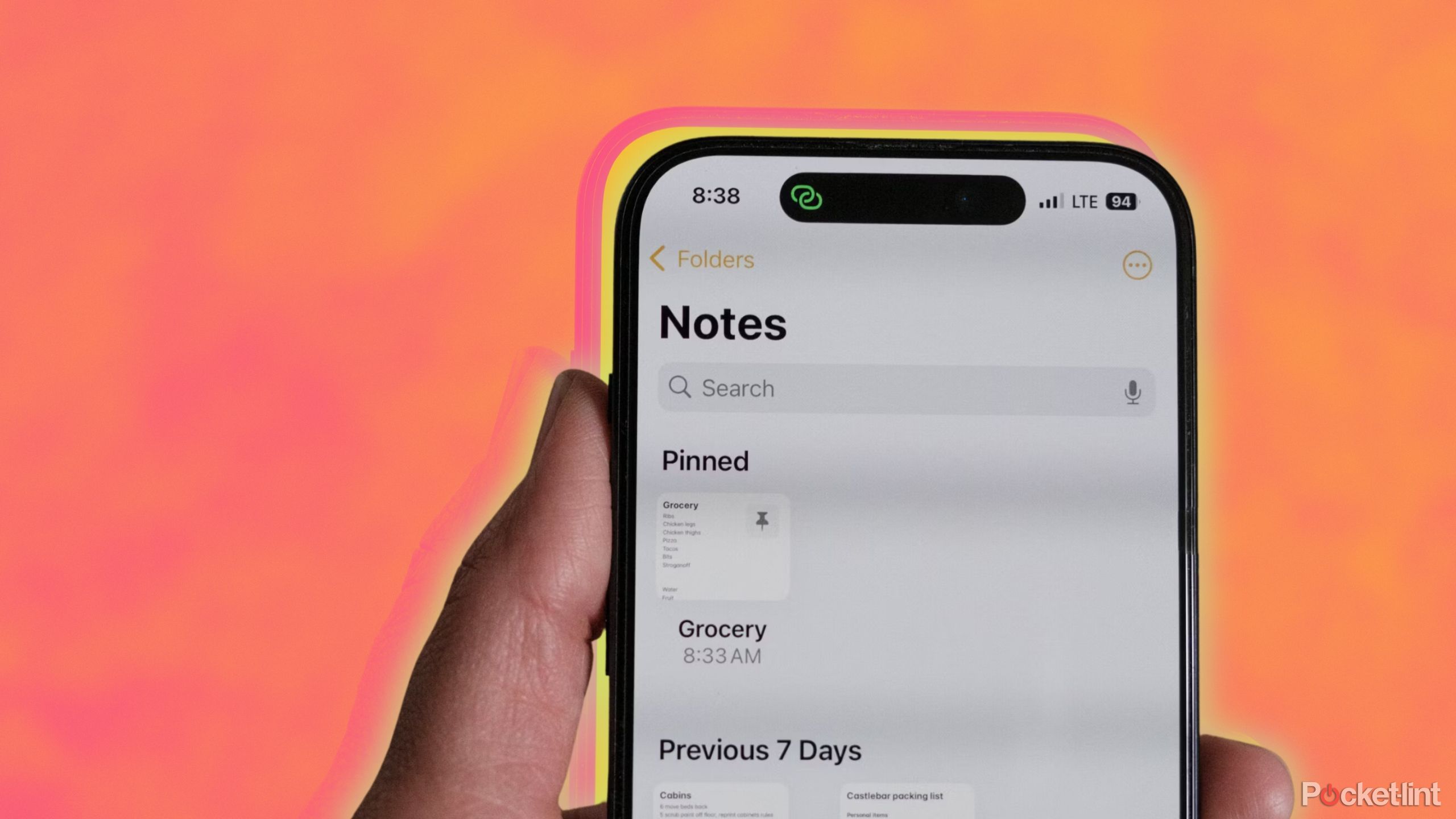 Apple Notes app on an iPhone that someone is holding against an orange background.