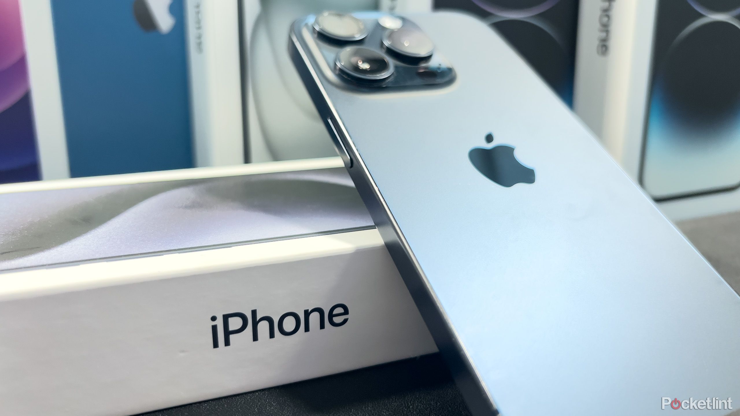 A blue iPhone 15 Pro leaning on a box
