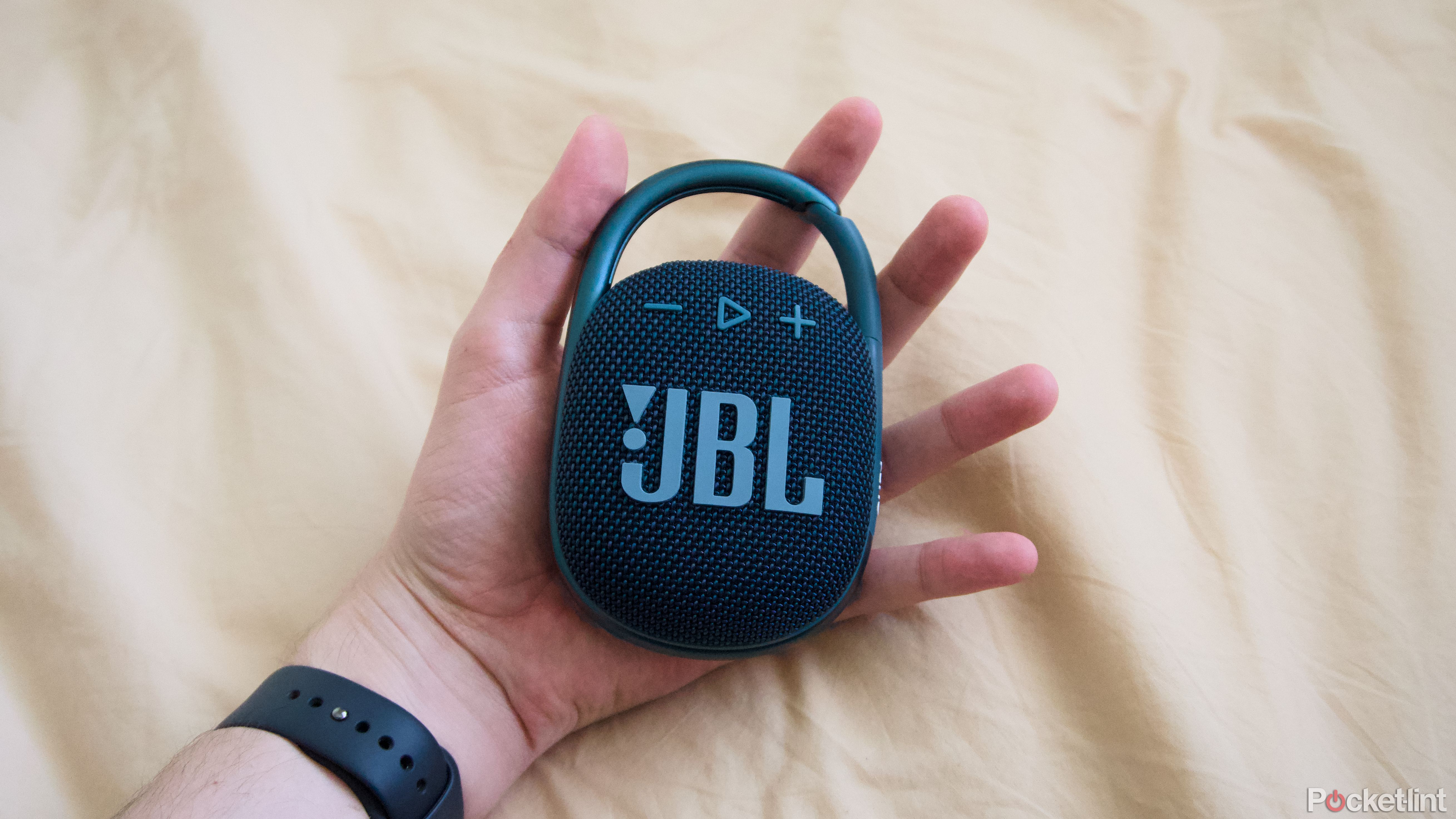 The JBL Clip 4 in the palm of a hand.