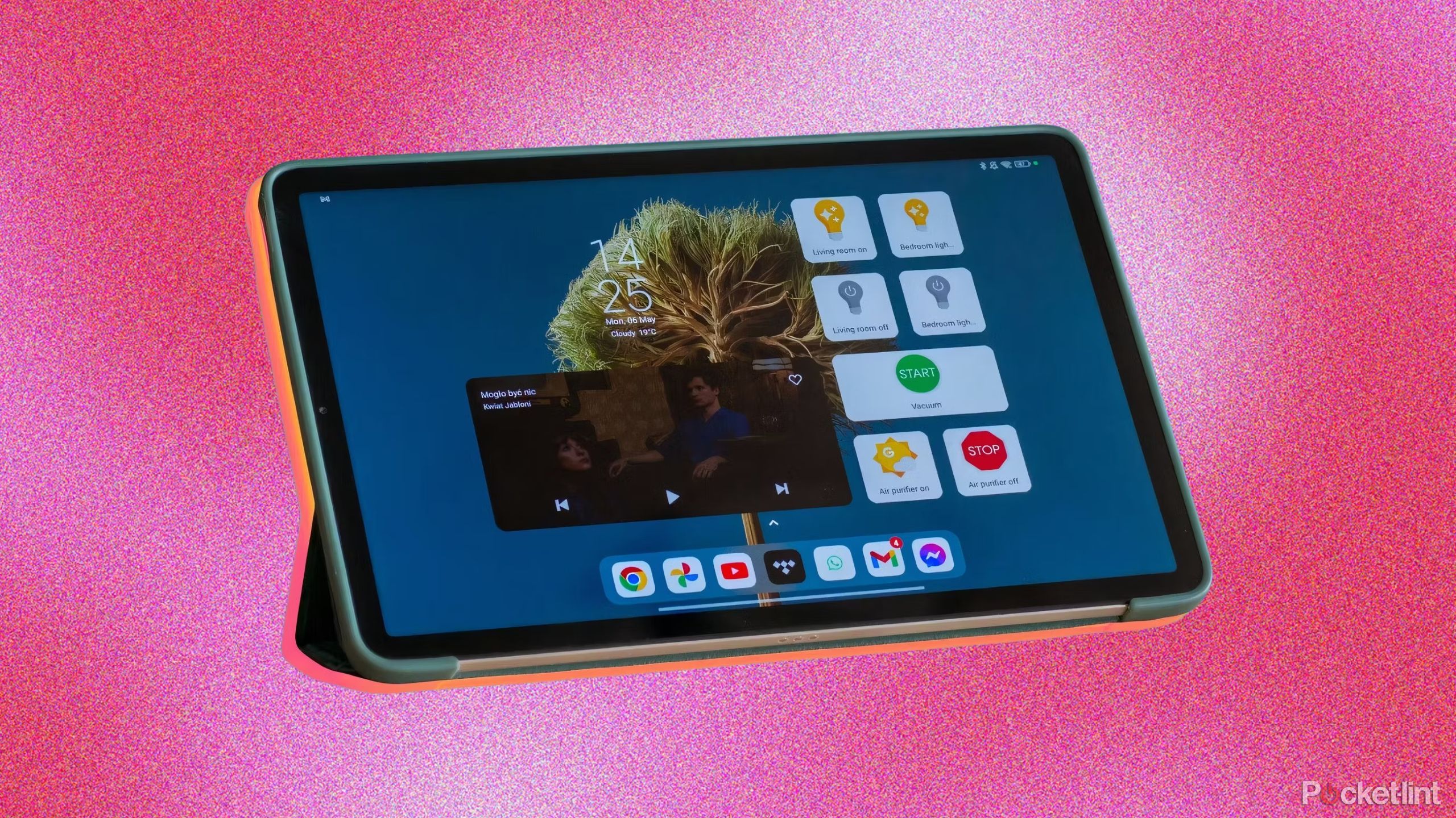 A tablet against a grainy pink background. 