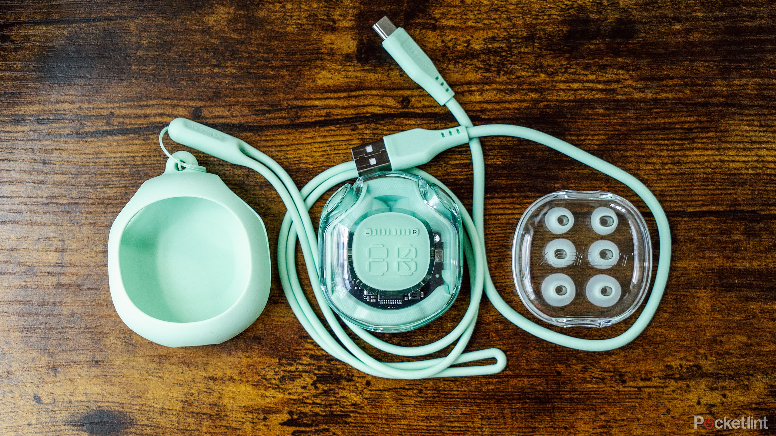 The Acefast Crystal (2) T8 earbuds and its accessories on a wood table.