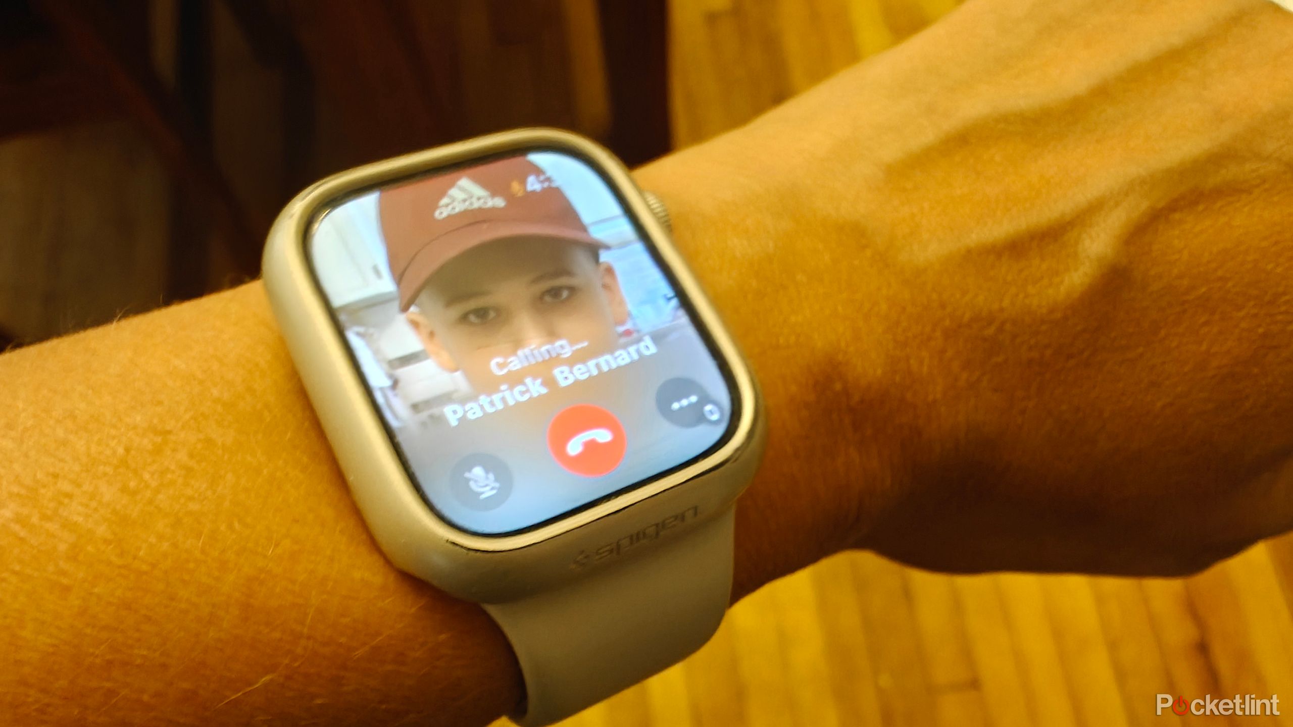 An Apple Watch on wrist showing that a call is being made to someone.