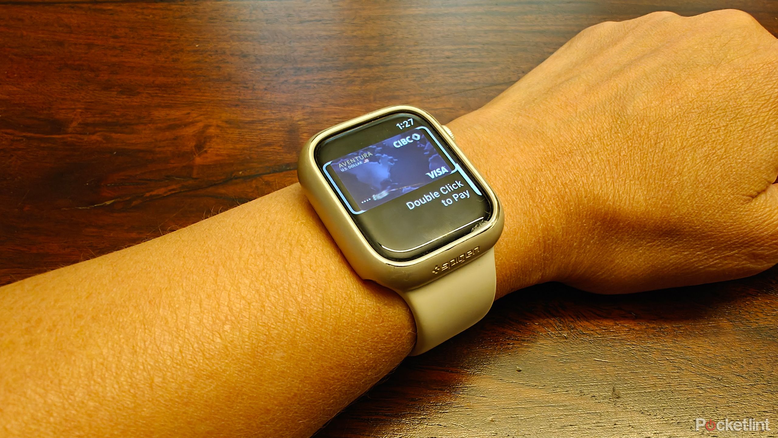 an Apple Watch on a wrist showing a credit card and Double Click to Pay