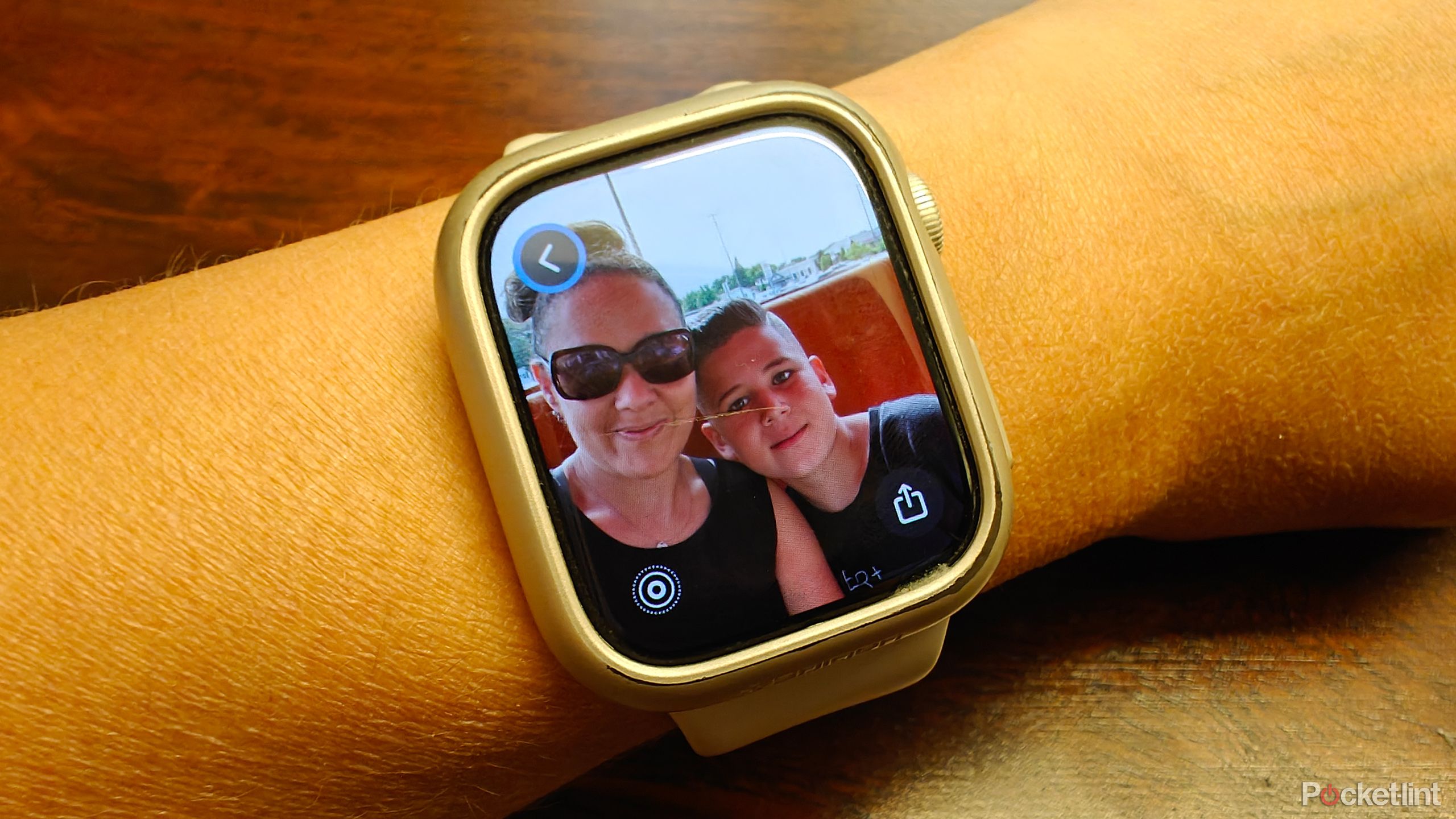 A woman and child posing for a photo in a restaurant shown on an Apple Watch screen.