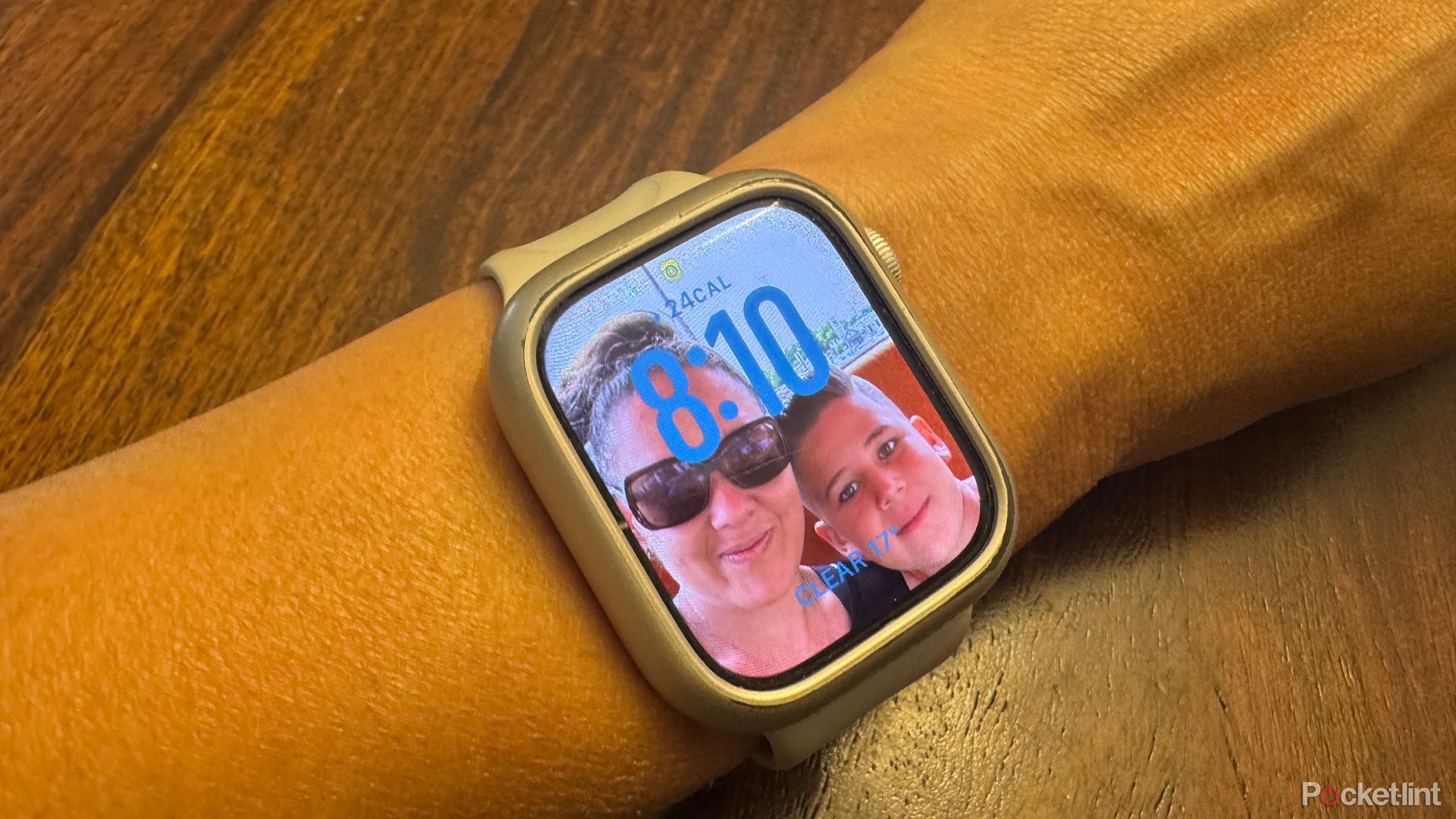 An Apple Watch on a wrist with a photo of a woman and child on it.