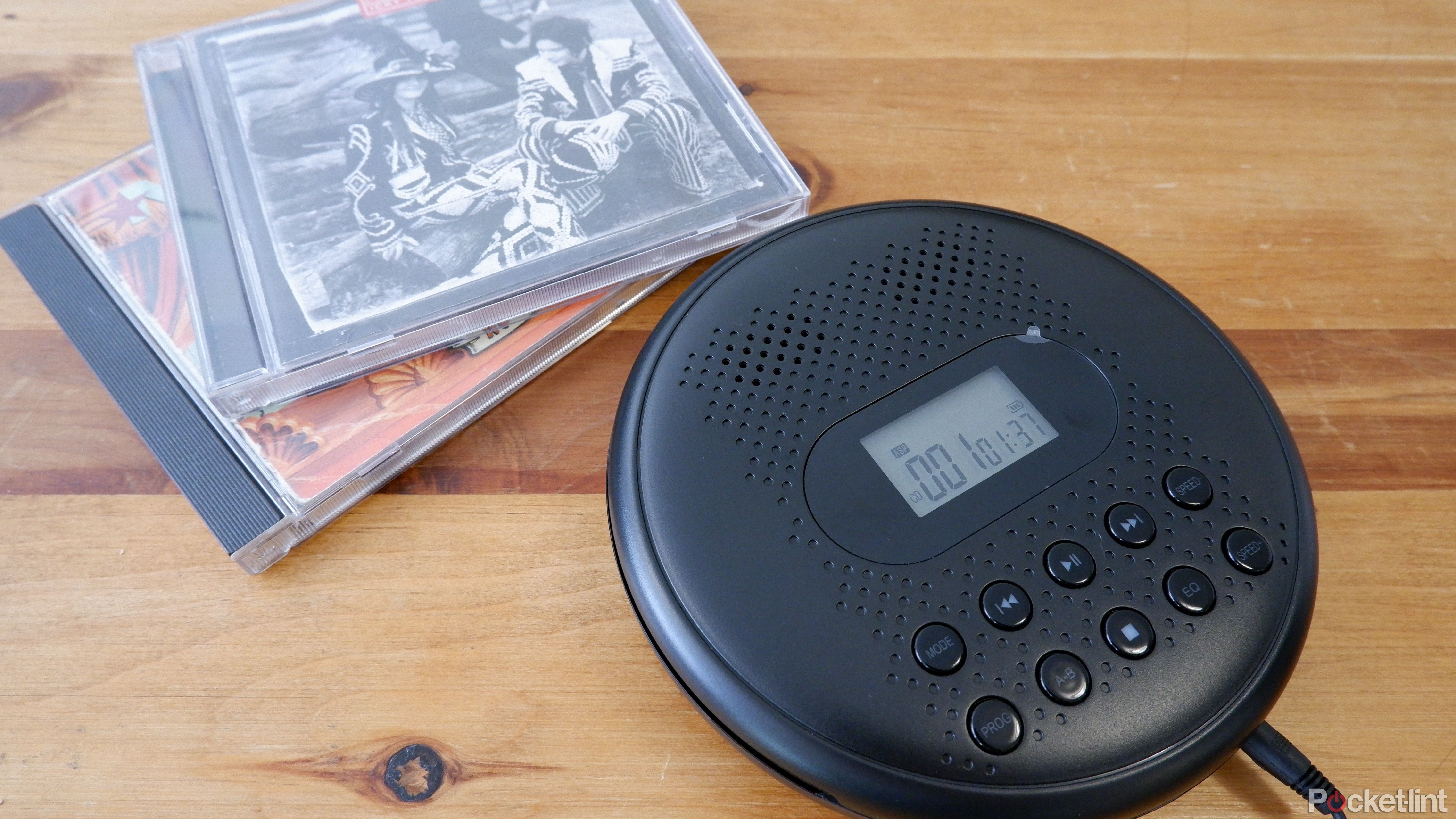 The ARAFUNA CD player beside two CD cases on a wooden coffee table