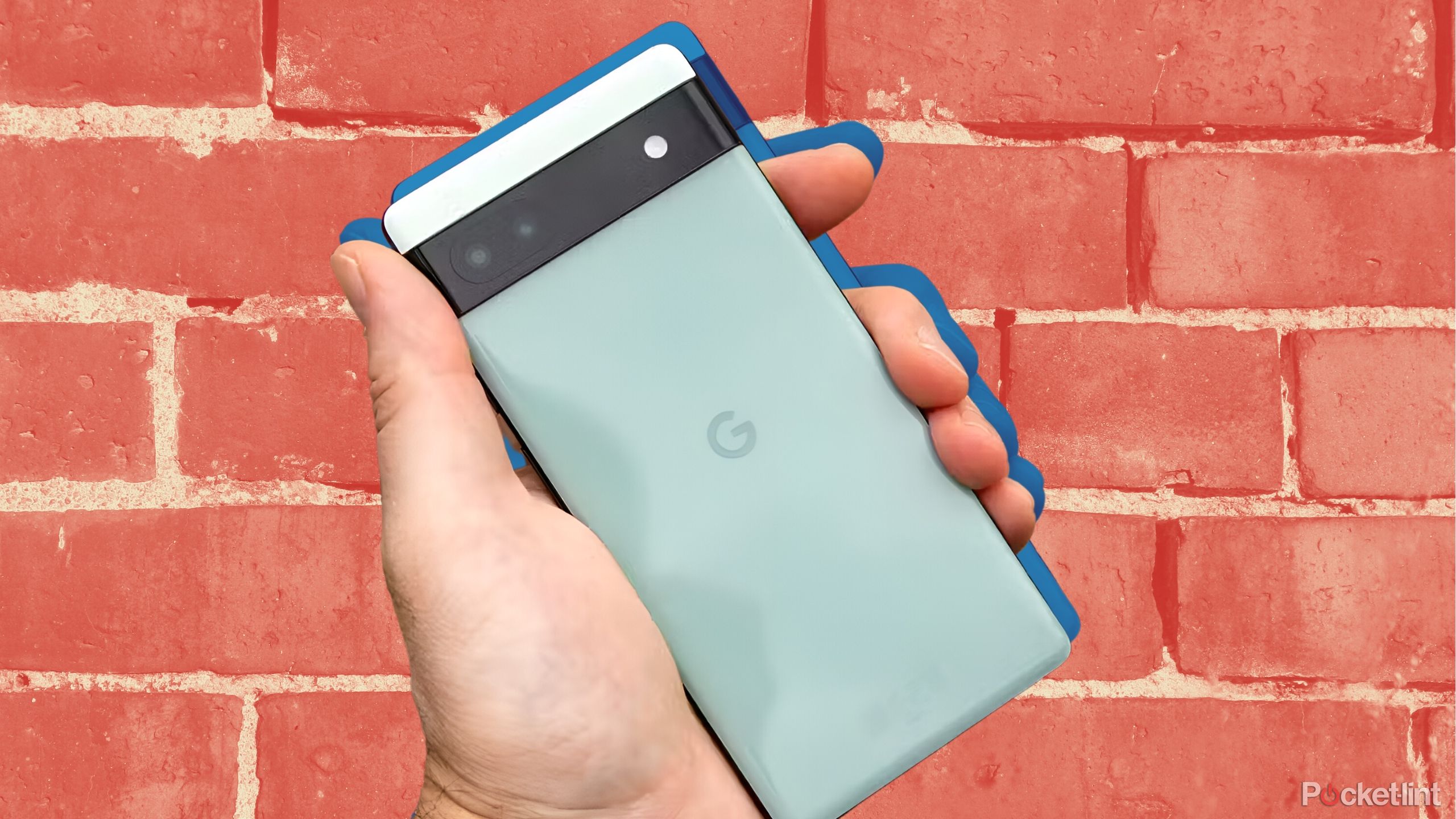 Pixel 6 phone in hand in front of brick stylized wall