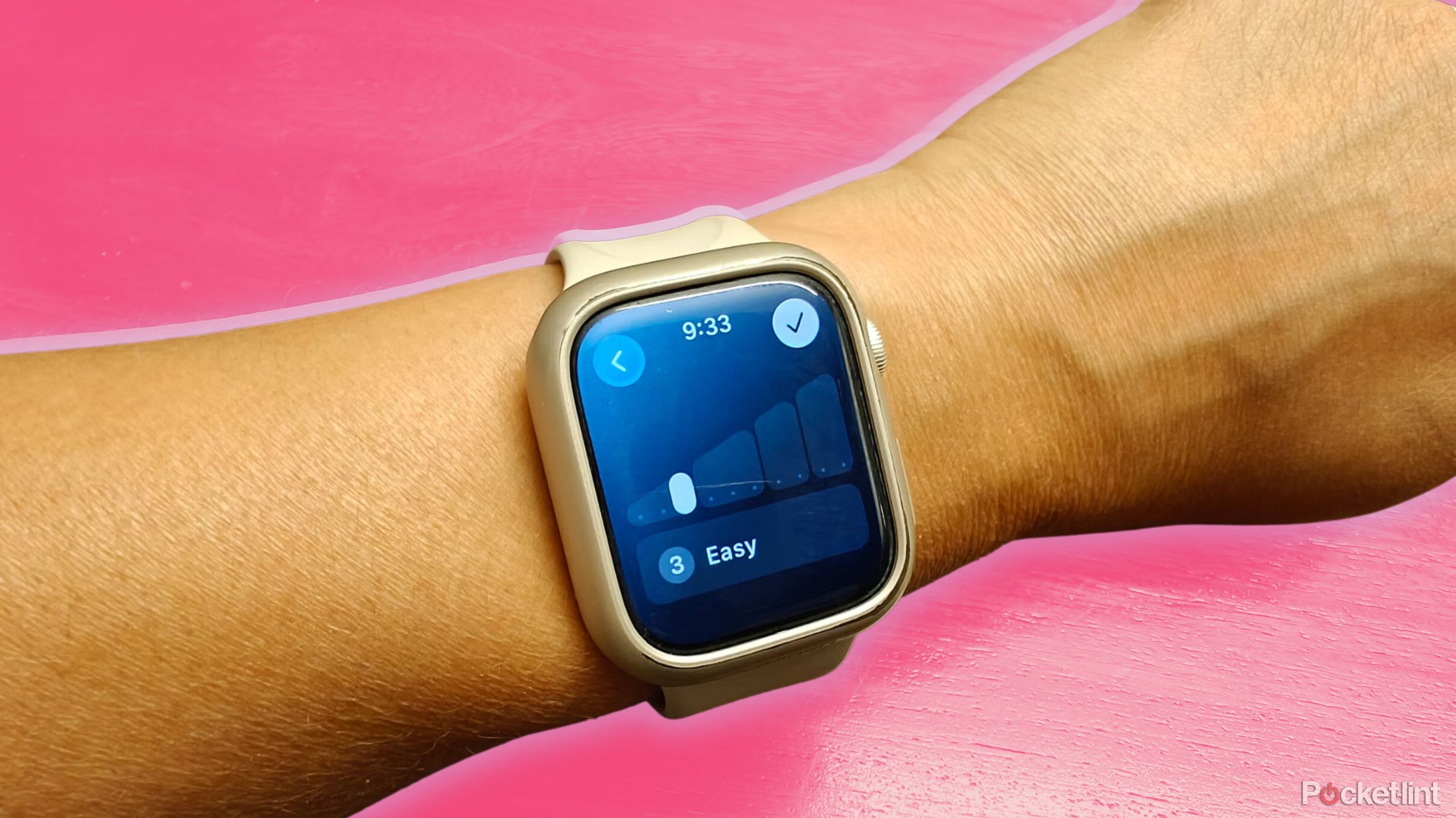 Apple Watch on wrist showing effort as easy against a pink background. 