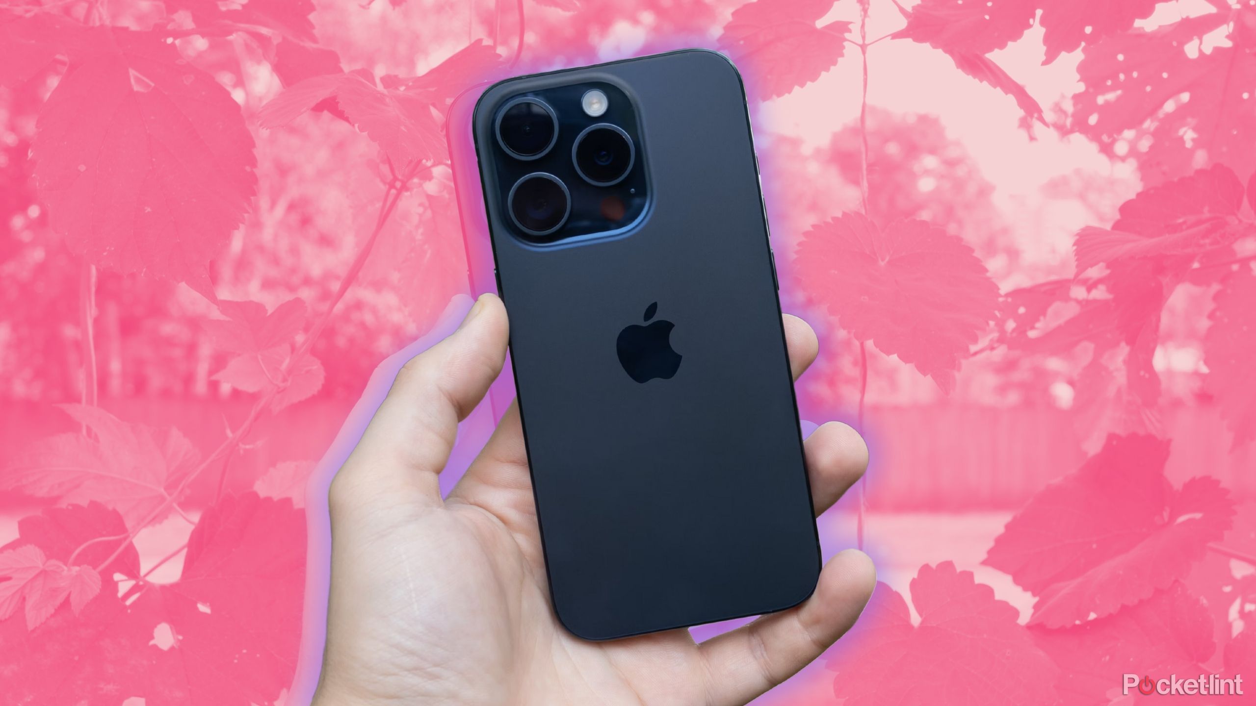 Apple's iPhone 15 Pro stands out against a background of pink leaves. 