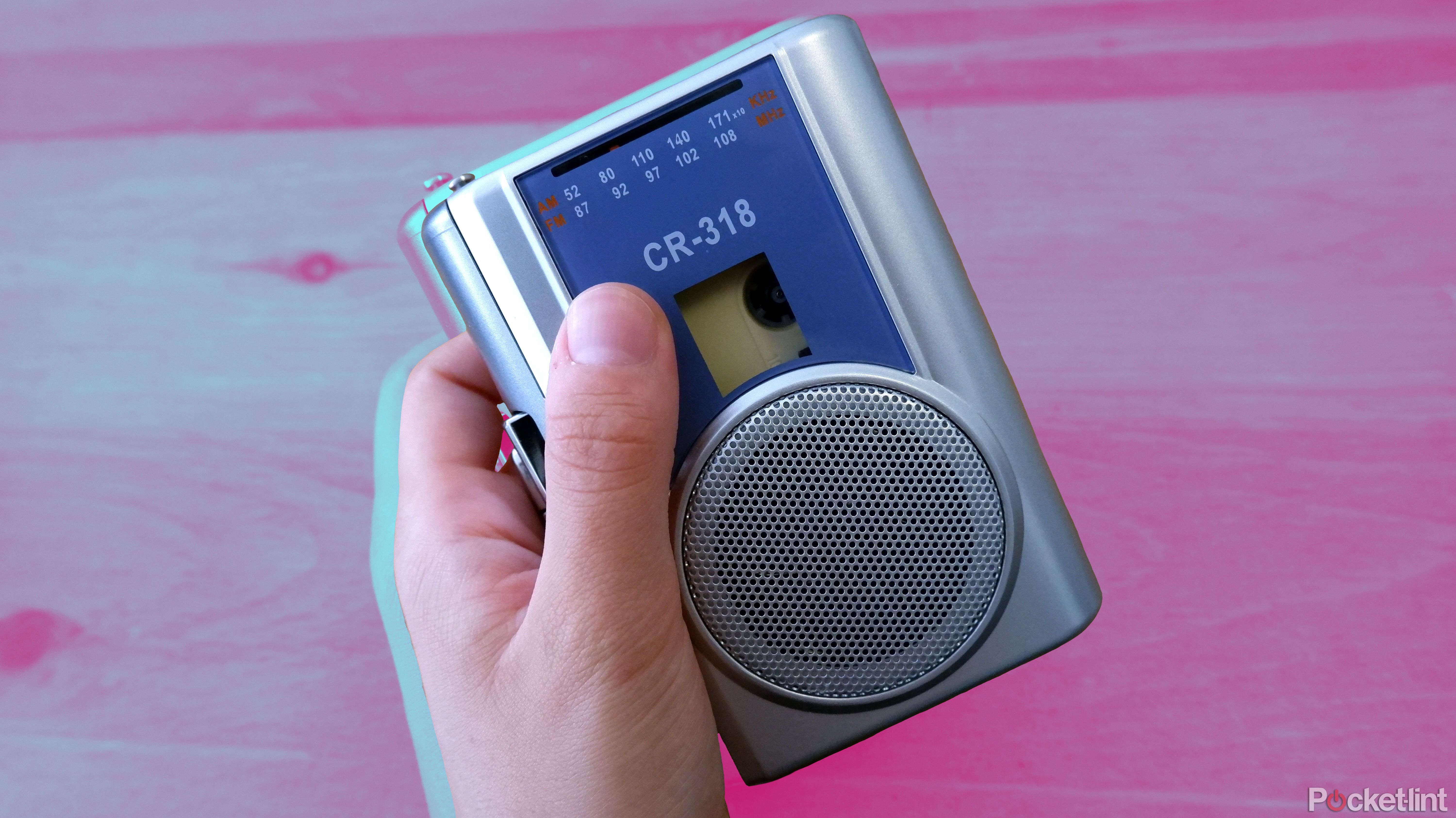 The Gracioso cassette player being held by a hand over a wooden coffee table