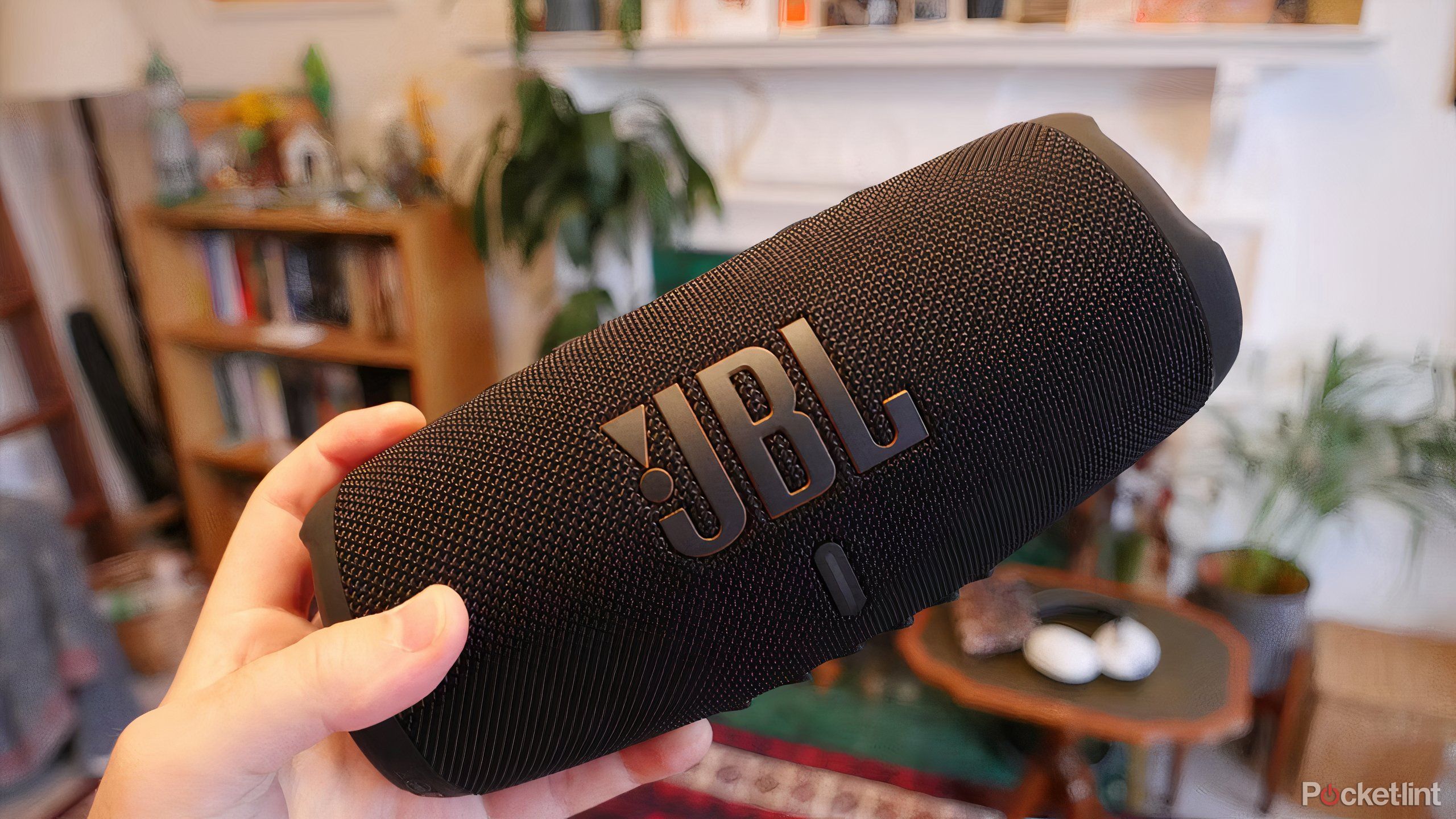 Holding the JBL charge 5 Wi-Fi in hand.