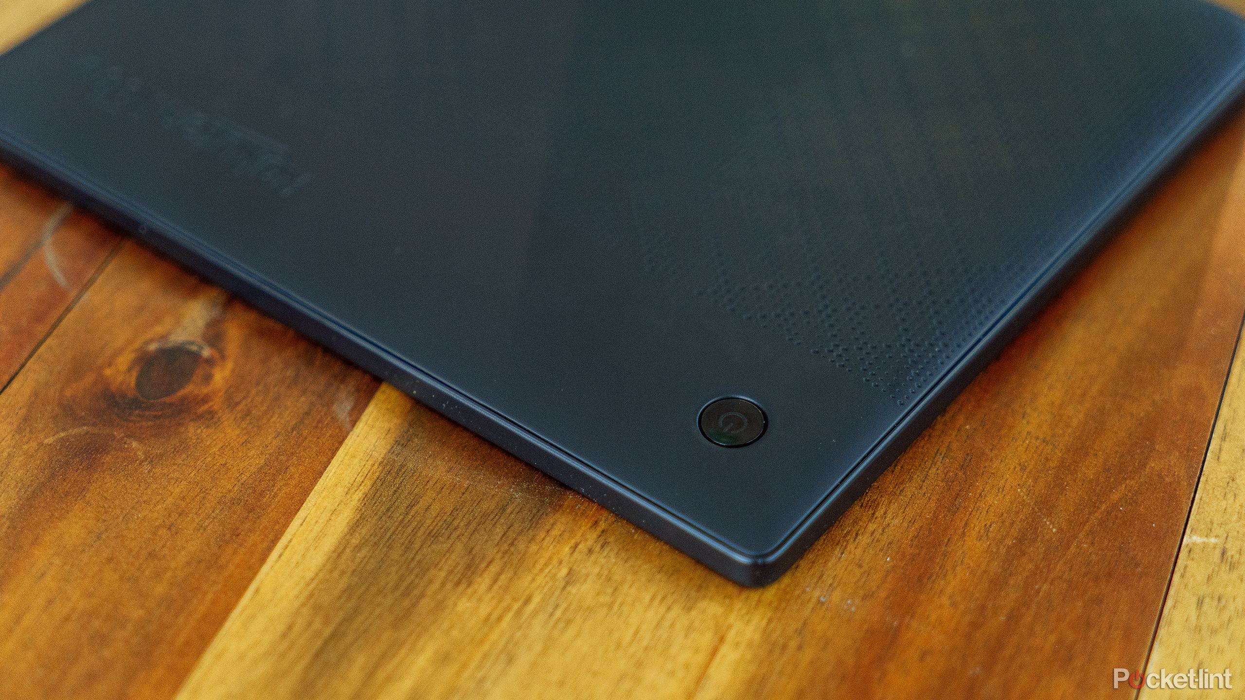 The power button on the Kobo Libra 2 is located on the wooden coffee table.